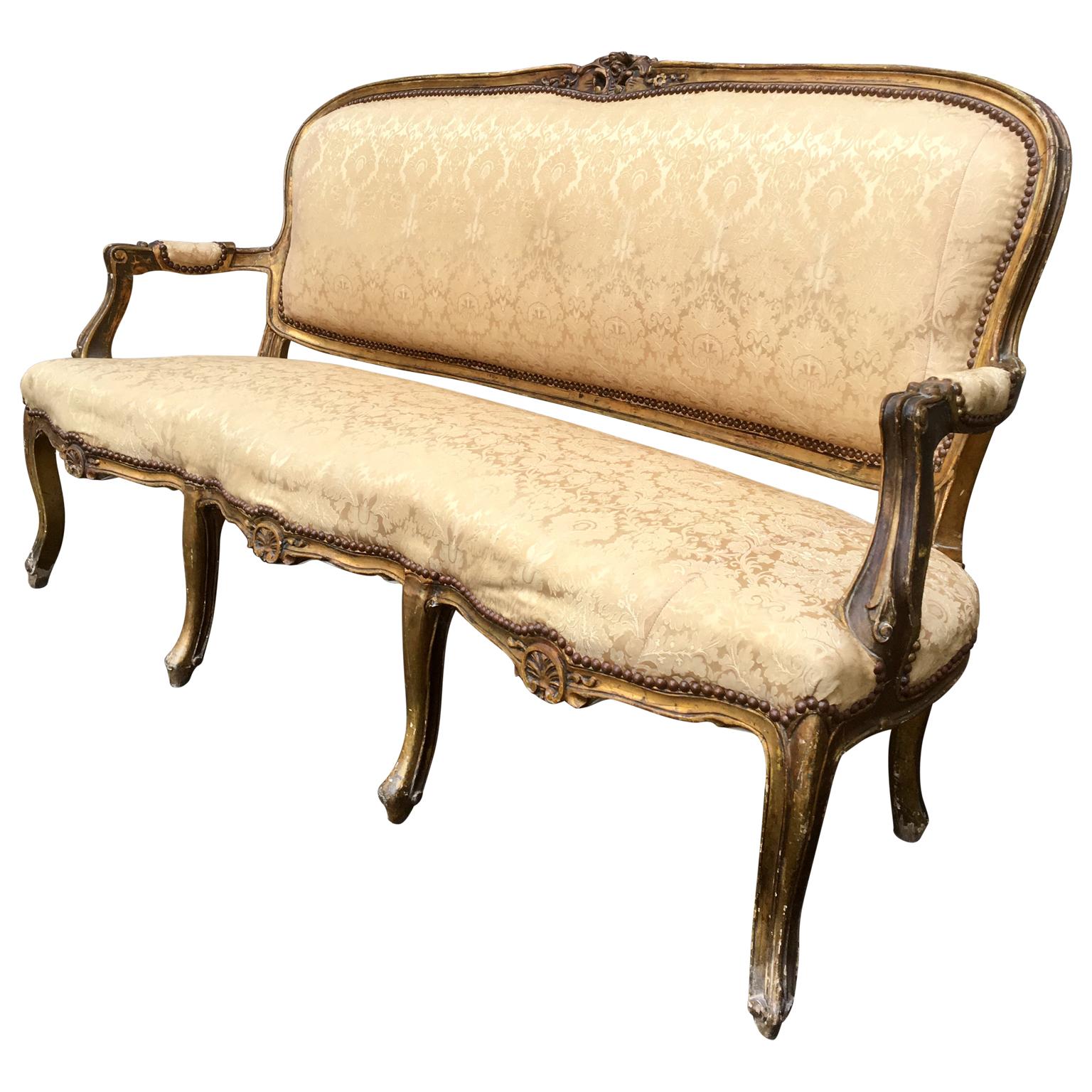 A gilt Napoleon III French sofa or bench from the end of the 19th century. Well carved and with an aged appropriate untouched original patina that gives you the feeling of being back in the 3rd French Empire lifestyle.