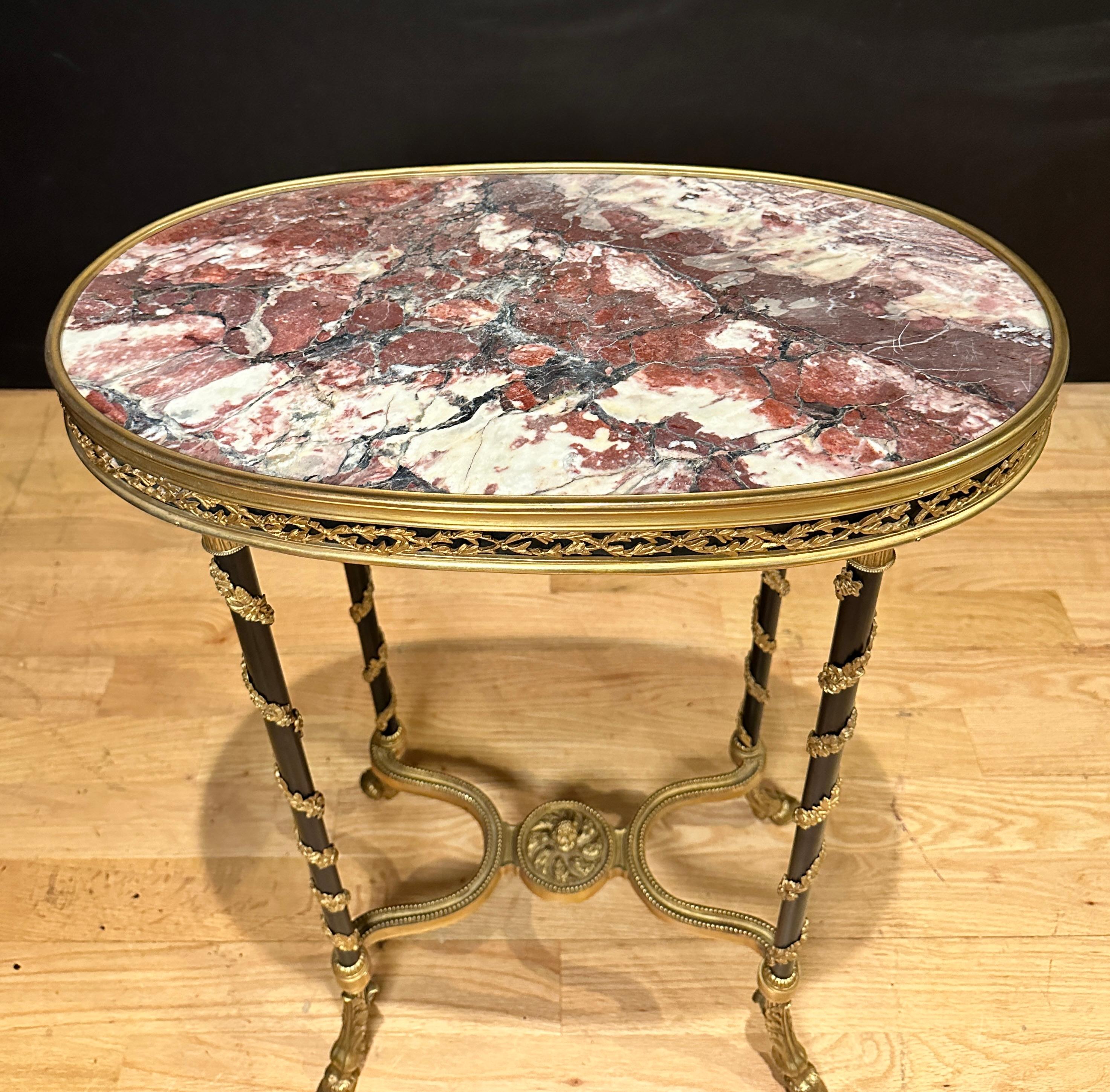 Table d'appoint/guéridon en bronze patiné et doré de style Louis XVI français du XIXe siècle de la plus haute qualité, avec plateau en marbre breccia violetta. Table de forme ovale à quatre colonnes fuselées reliées par une entretoise inférieure en