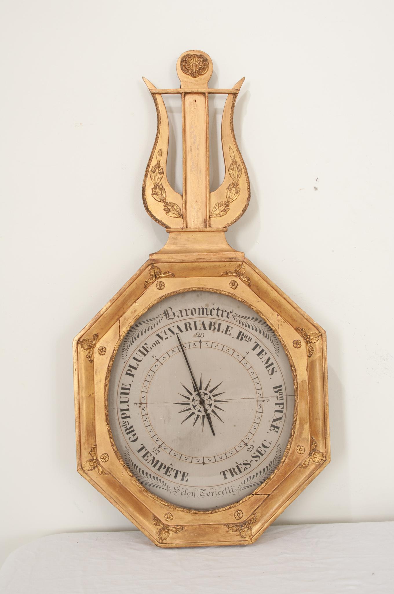 A delightful 19th Century French gold-gilt barometer circa 1850.  This early instrument of meteorology has been adorned with a molded and decoratively trimmed octagonal frame dotted with rosette and shell cartouche corners that has been painted gold