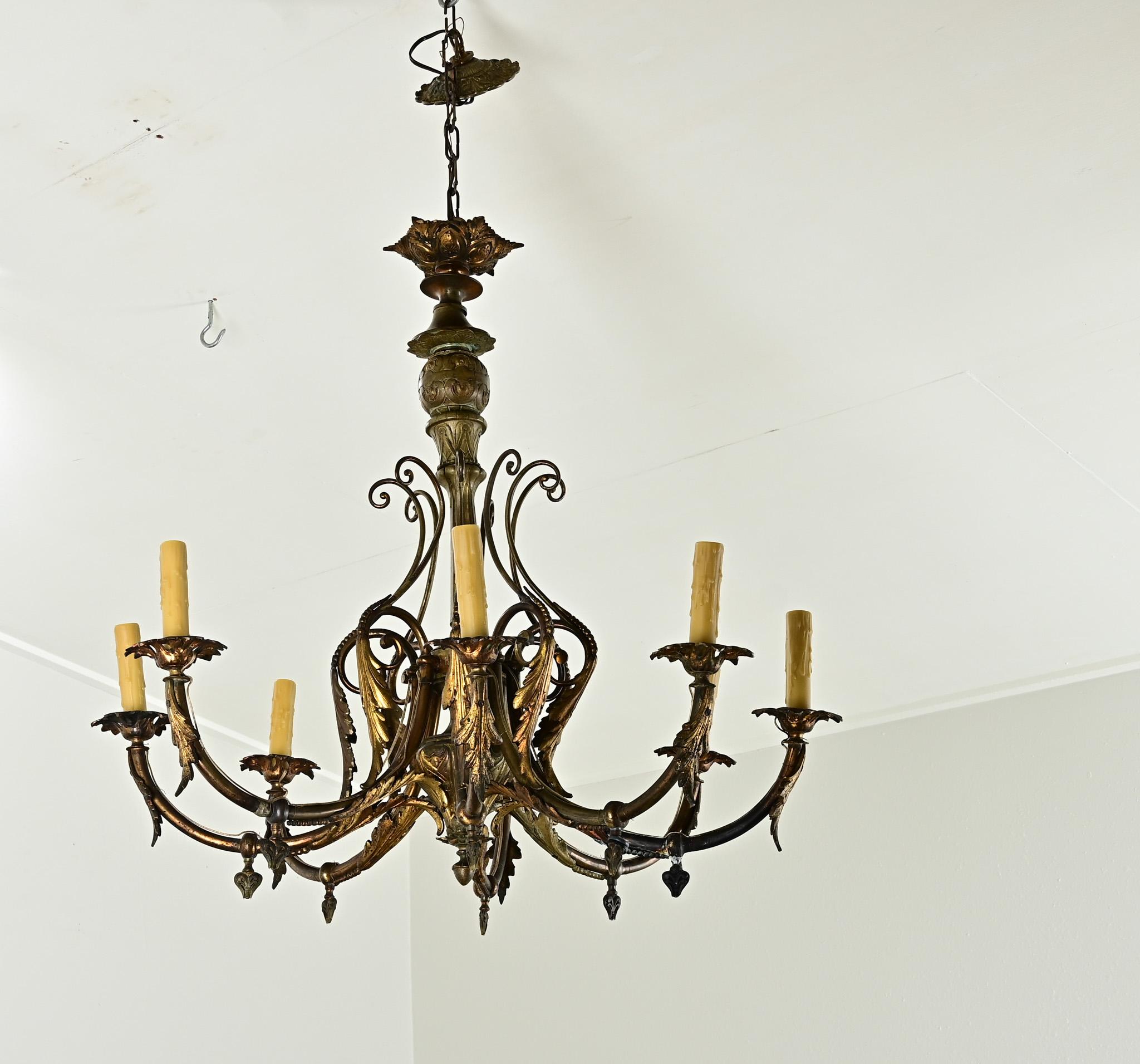 Uno squisito lampadario in bronzo dorato proveniente dalla Francia del XIX secolo con tutto il fascino del Rococò Revival. Otto  I bracci a spirale che si innalzano dalla colonna centrale ornata sono enfatizzati dalla decorazione fogliare a forma di