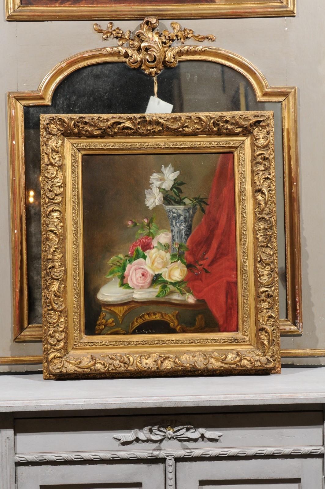 A French still-life framed oil painting from the 19th century, depicting flowers set on a Rococo table. Born in France during the politically dynamic 19th century, this exquisite oil painting depicts elegant flowers, some of them displayed in a blue