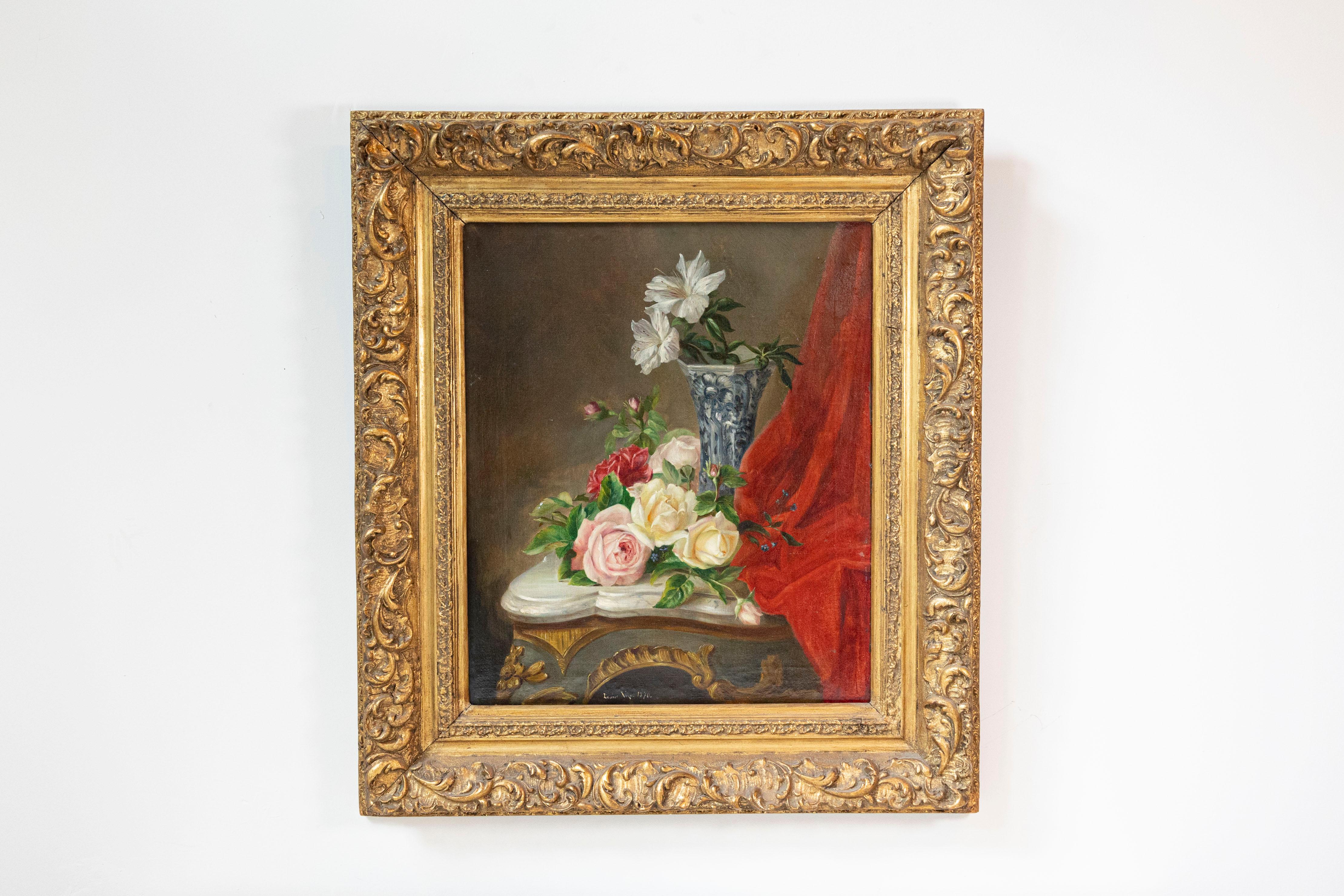 A French still-life framed oil painting from the 19th century, depicting flowers set on a Rococo table. Born in France during the politically dynamic 19th century, this exquisite oil painting depicts elegant flowers, some of them displayed in a blue