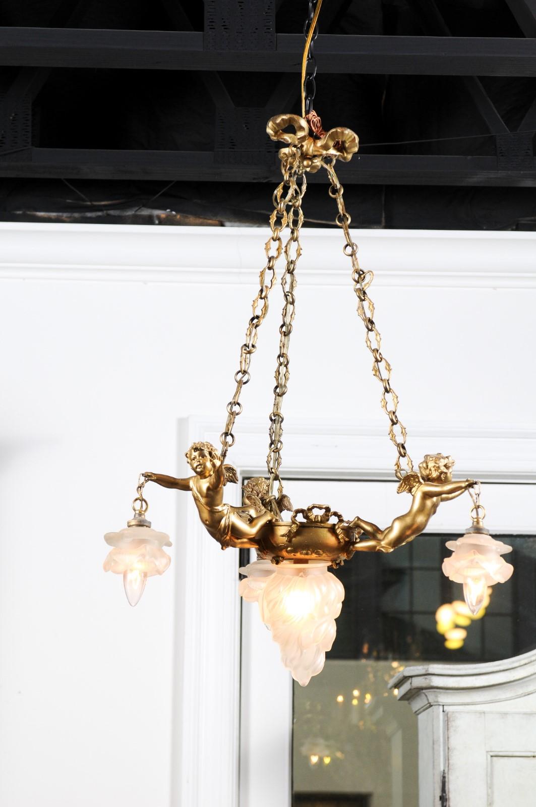 Français Lustre français du 19e siècle en métal doré avec trois chérubins tenant les lampes en vente