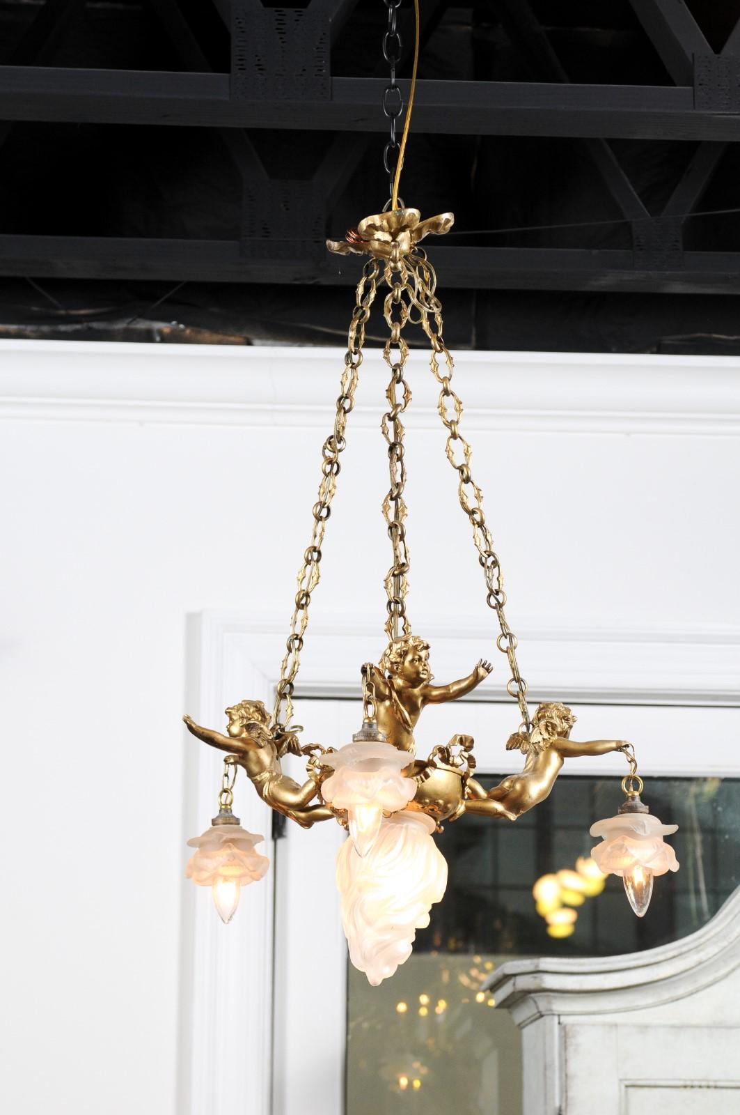 Doré Lustre français du 19e siècle en métal doré avec trois chérubins tenant les lampes en vente