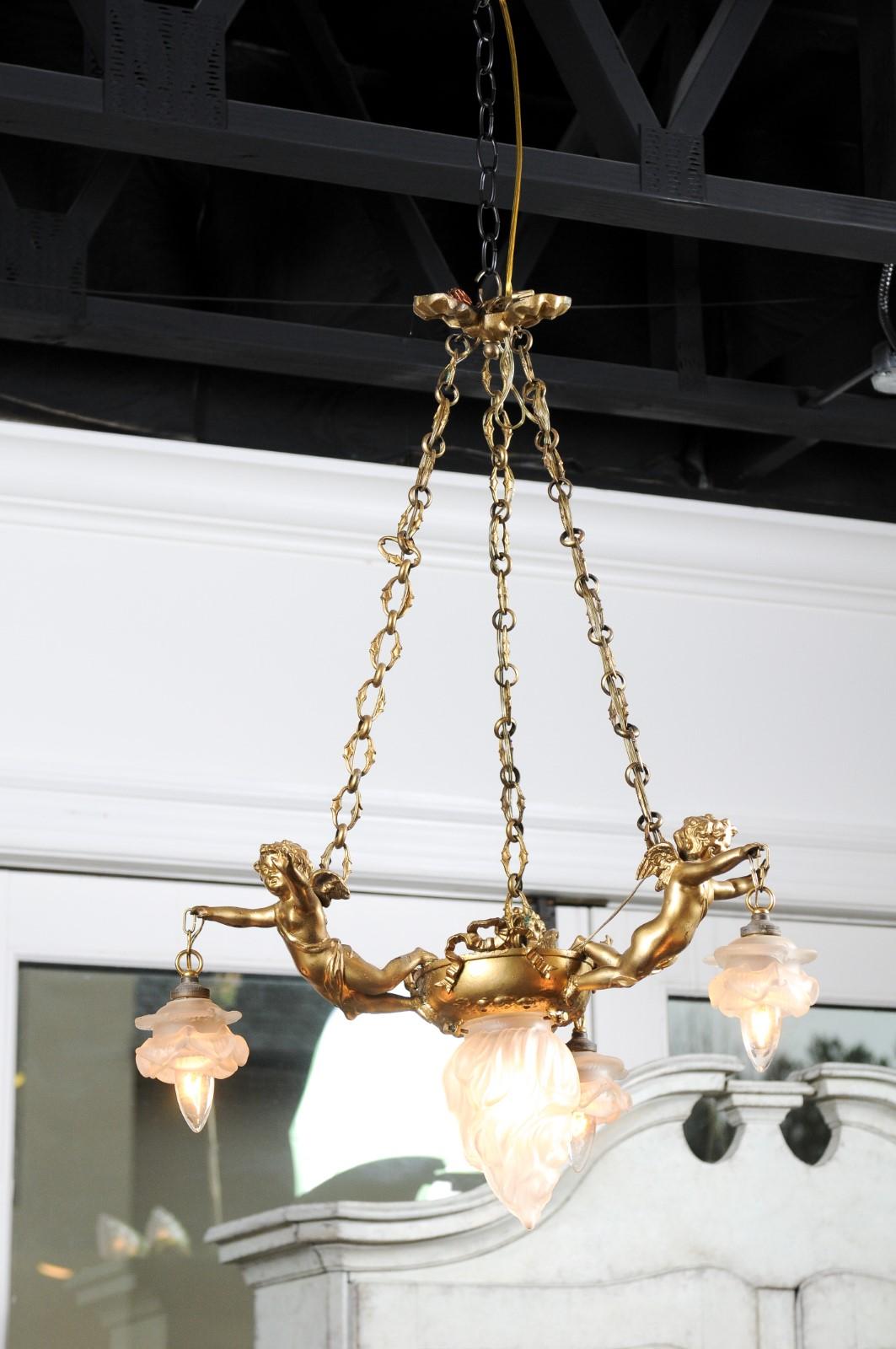 XIXe siècle Lustre français du 19e siècle en métal doré avec trois chérubins tenant les lampes en vente