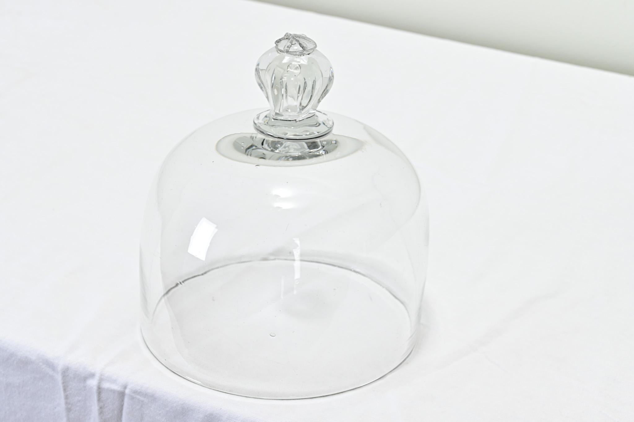 A French hand blown dome used for covering cheese or pastries, most likely for display in a mercantile shop. This cloche has a decorative blown glass knob. Be sure to view the detailed images of this culinary antique.