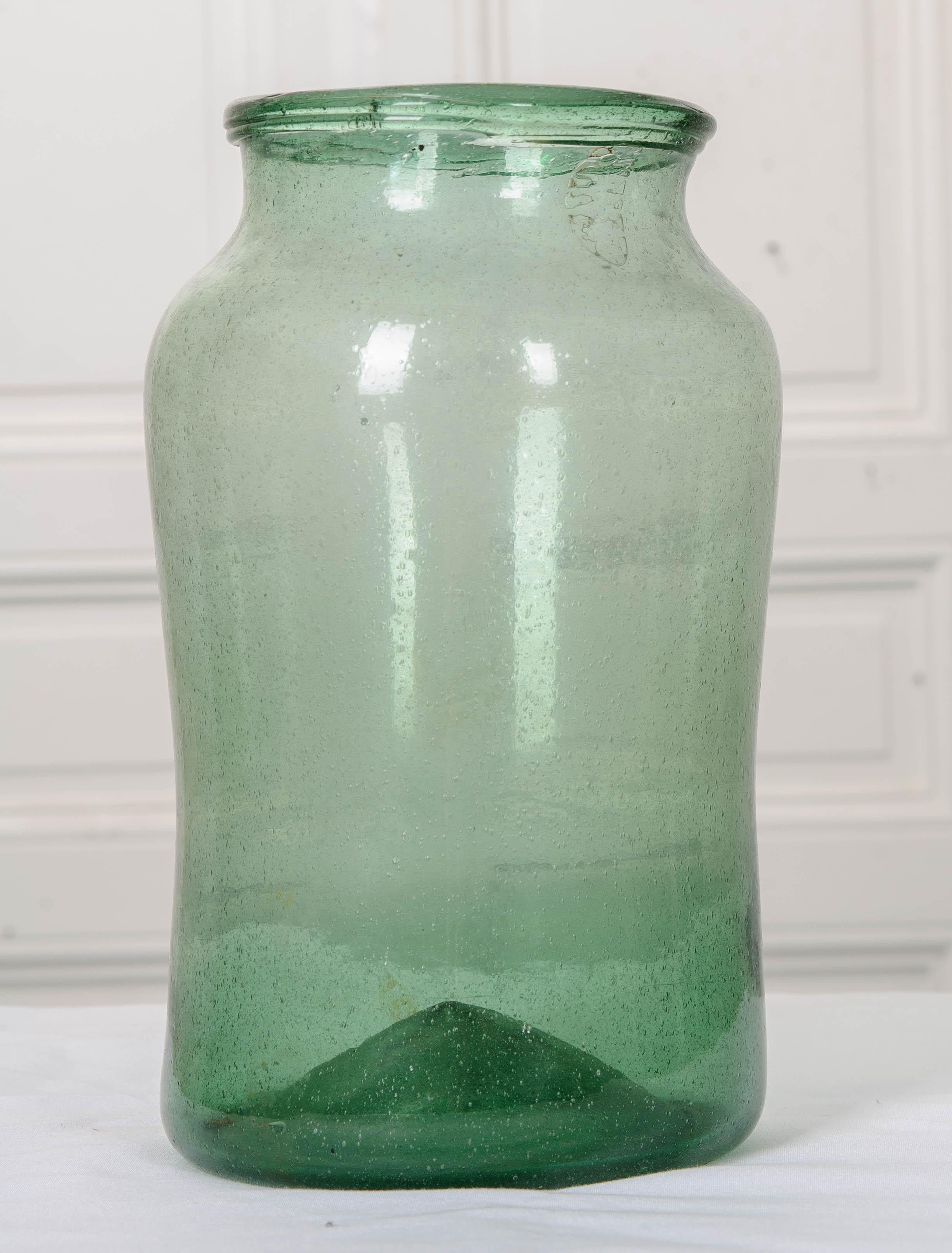 A wonderfully wonky blown-glass jar from 19th century, France. The jar’s less-than-perfect symmetry is a testament to the early methods of glassmaking. The glass has a wonderful, cool- blue or green coloration and is teeming with tiny bubbles that