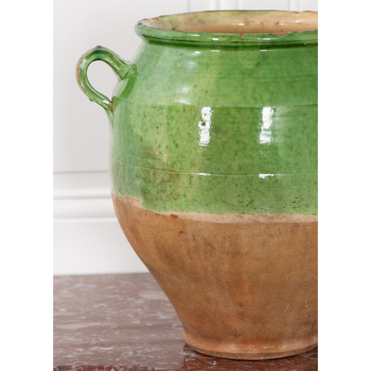 Green glazed confit jar for storing meat and fat. Most of these jars are only glazed on the top half of the exterior and on the inside. While the exterior is green, the interior is glazed in yellow. The bottom half of the exterior is unglazed as it