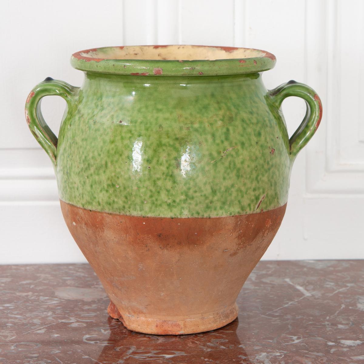 Light green glazed confit jar for storing meat and fat. Most of these jars are only glazed on the top half of the exterior and on the inside. While the exterior is green with a light, creamy undertone, the interior is glazed in yellow. The bottom