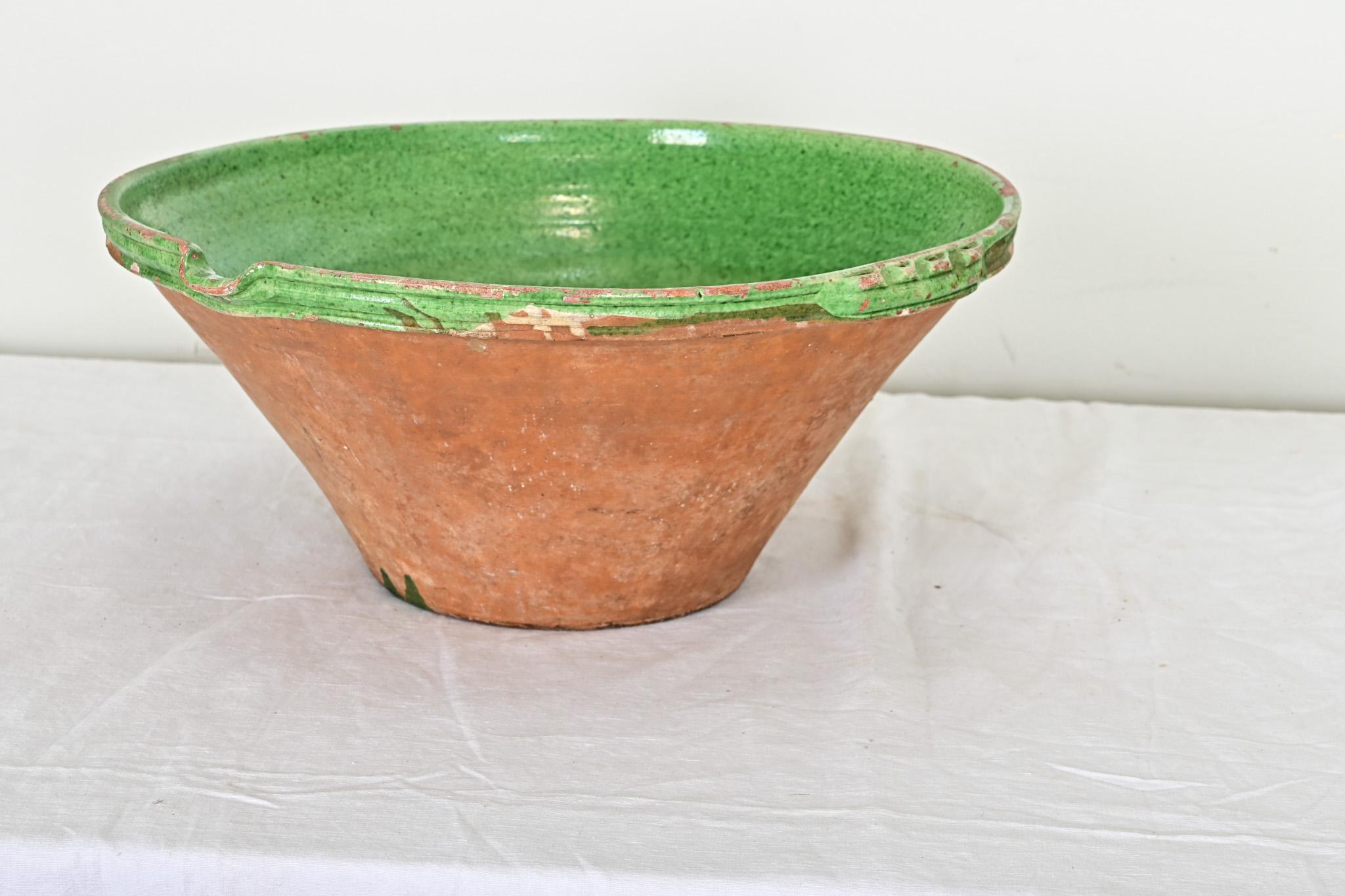 A dazzling emerald green glaze over terracotta elevates this 19th century French cream bowl from its humble dairy farm origins to the modern kitchen. The rim of the bowl offers a small spout for pouring off the precious cream, with two ridged