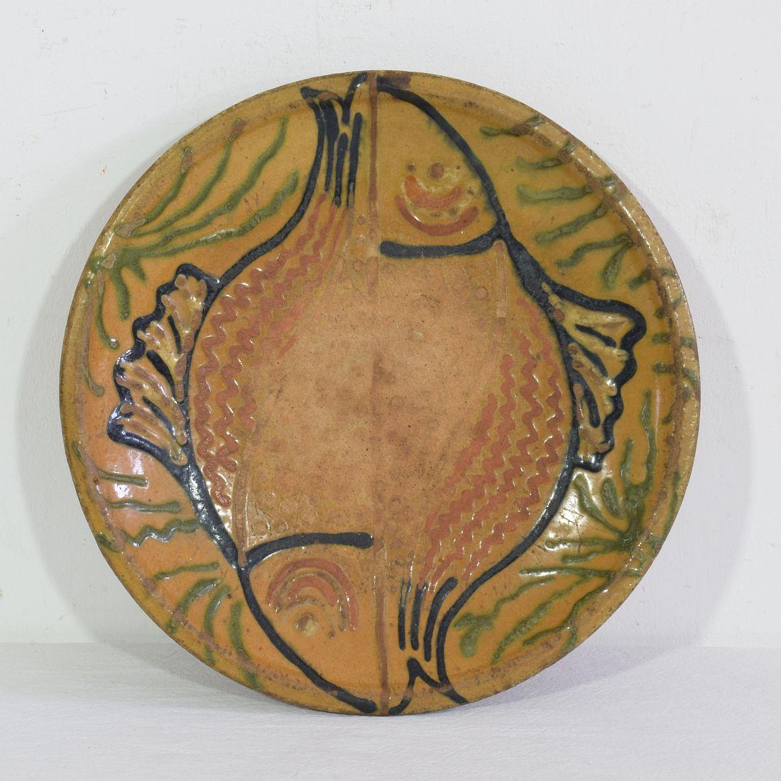 Wunderbar glasiert  Keramikteller/Schale mit der Darstellung zweier Fische. Ein großartiges Stück Volkskunst.
Frankreich um 1850-1900. Verwittert