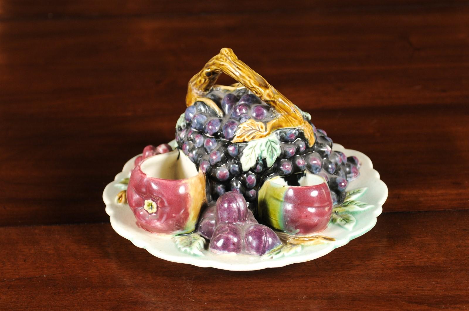 A French Majolica fruit dish from the 19th century with lid. Born in France during the politically dynamic 19th century, this dish attracts our attention with its delicate arrangement of mouth-watering fruits surrounding a central grape-themed
