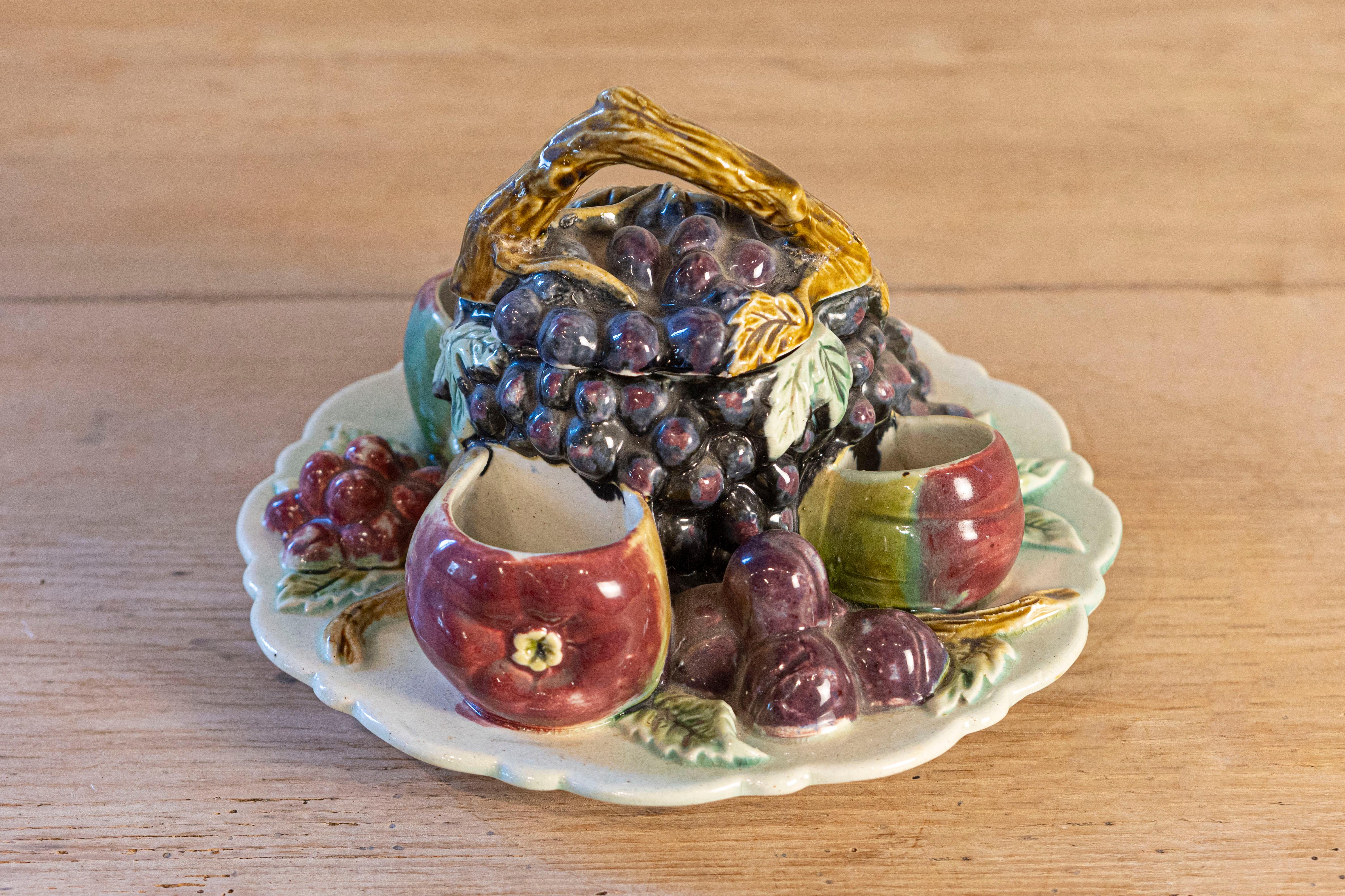 A French Majolica fruit dish from the 19th century with lid. Born in France during the politically dynamic 19th century, this dish attracts our attention with its delicate arrangement of mouth-watering fruits surrounding a central grape-themed