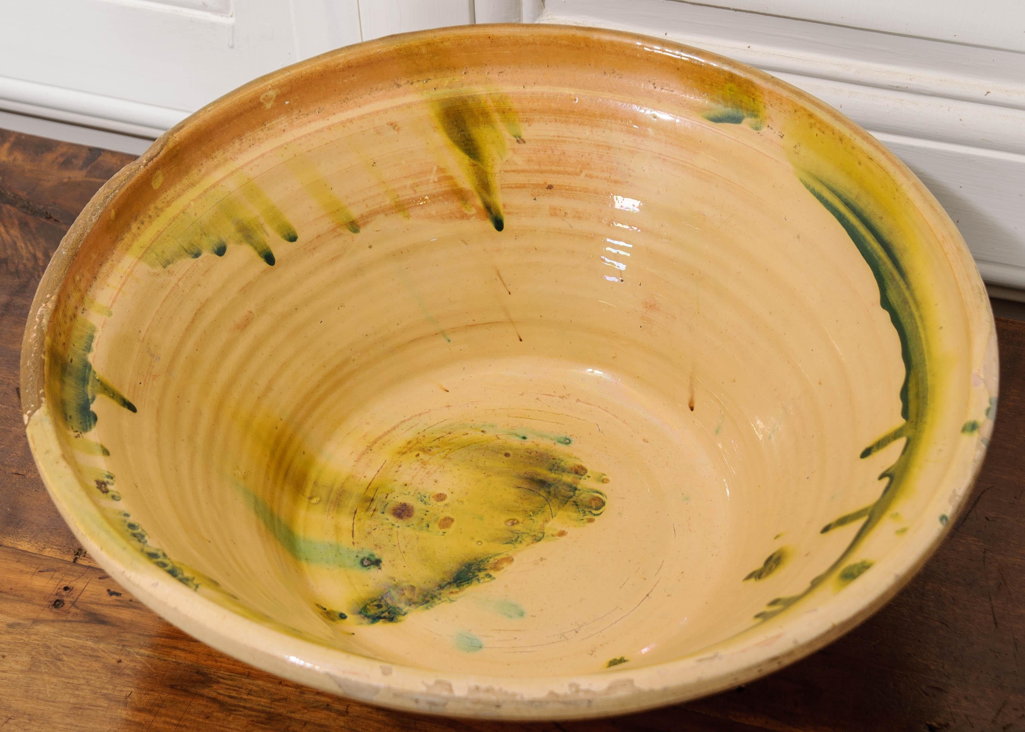 A fine mixing bowl made in 19th century, France. The bowl has been glazed with a rich, glossy yellow and green interior. This beautiful example of antique kitchenalia will make a wonderful centerpiece for your dining table, or perhaps a cachepot for