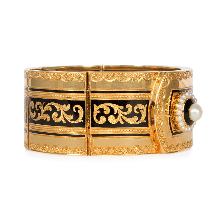 An antique gold and black enamel engraved foliate motif bracelet designed as a cuff with a pearl button, in 18k.  France

Inner circumference: 17.3 cm