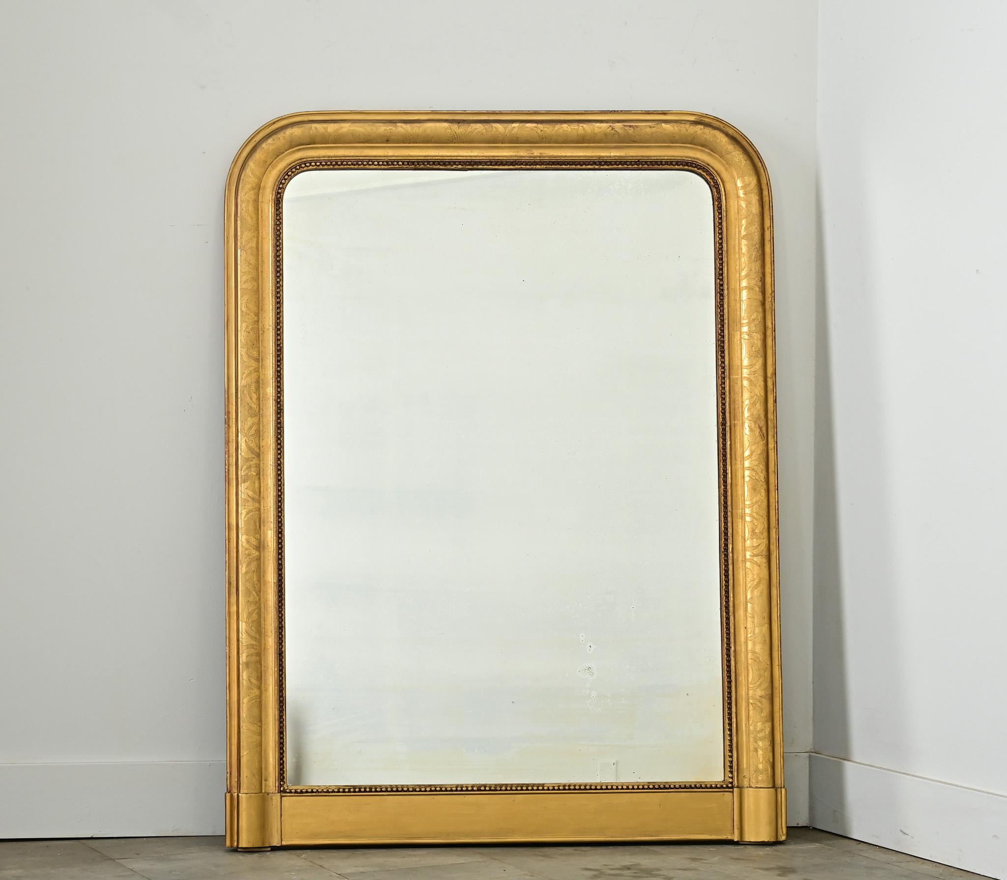 Elegante specchio da camino francese del XIX secolo con doratura e vetro originale. La modanatura ad arco è un classico di Louis Philippe, tracciata da un motivo fogliare che è piuttosto sottile sotto le macchie di ossidazione e patina che rivelano