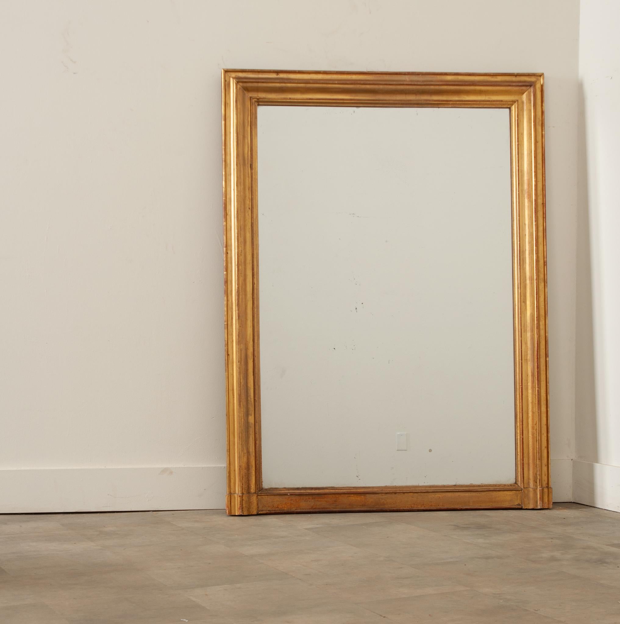 A shimmering French gold gilt mantel mirror, hand-crafted in France in the 19th century. This classic mantle mirror is in excellent condition with its original mercury glass and sturdy wood backing. Elegant and refined with lustrous gold gilt and a