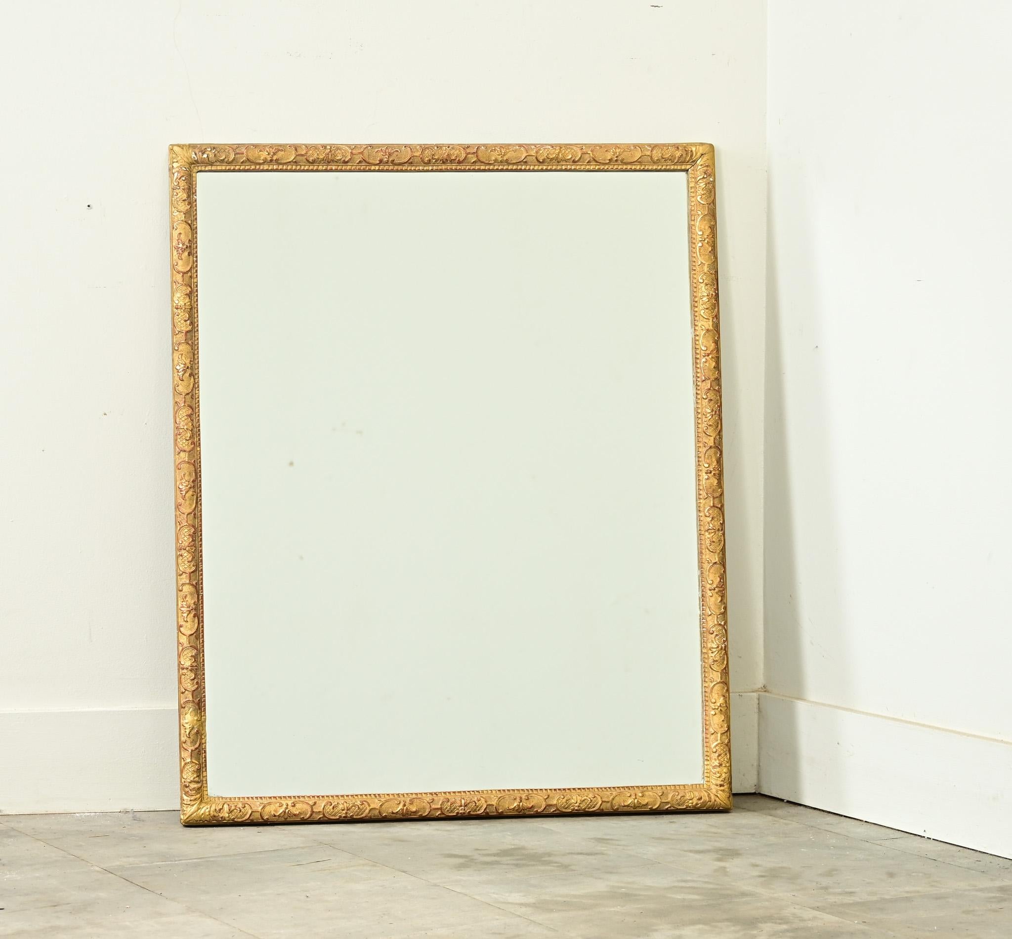 Merveilleux miroir doré français du 19ème siècle, le cadre fin est dense avec une texture et un motif pour égayer n'importe quelle pièce. De subtils motifs sculptés de fleurs de lys entourent la moulure, alternativement orientés vers le haut ou vers
