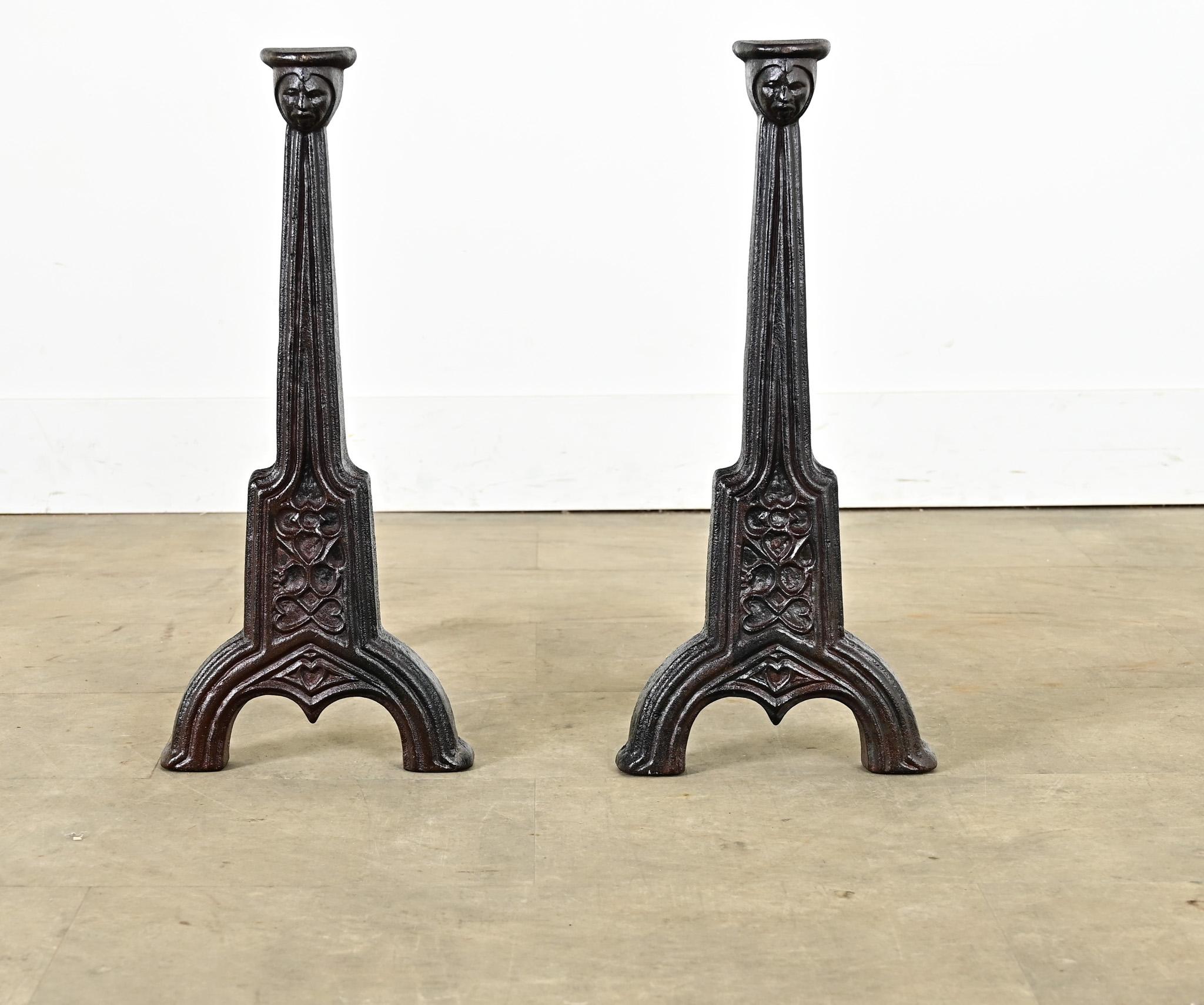 A sculptural pair of French 19th century cast iron fireplace andirons–or chenets–guardians of the hearth who draw as much attention as the roaring fire behind them. Stylistically they reference Gothic Revival and Art Nouveau verging on Deco: the