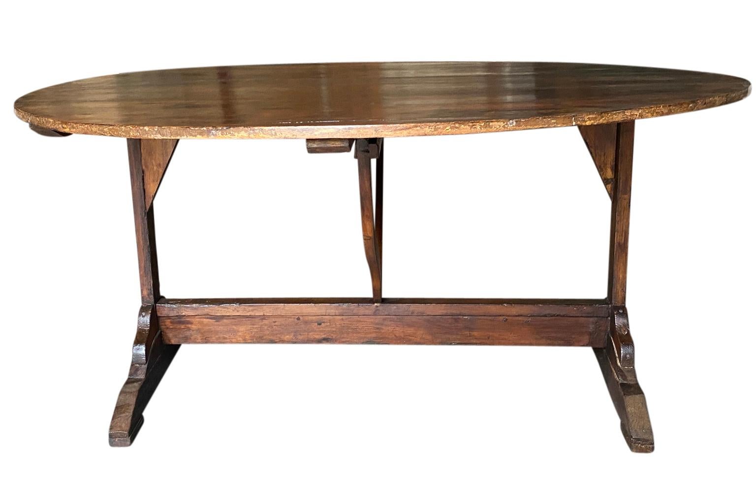 A very grand scale table Vigneron - wine tasting table from the South of France. Beautifully constructed from chestnut and pine in an oval shape and tilting top. Terrific as a breakfast table or smaller dining table. Great patina.