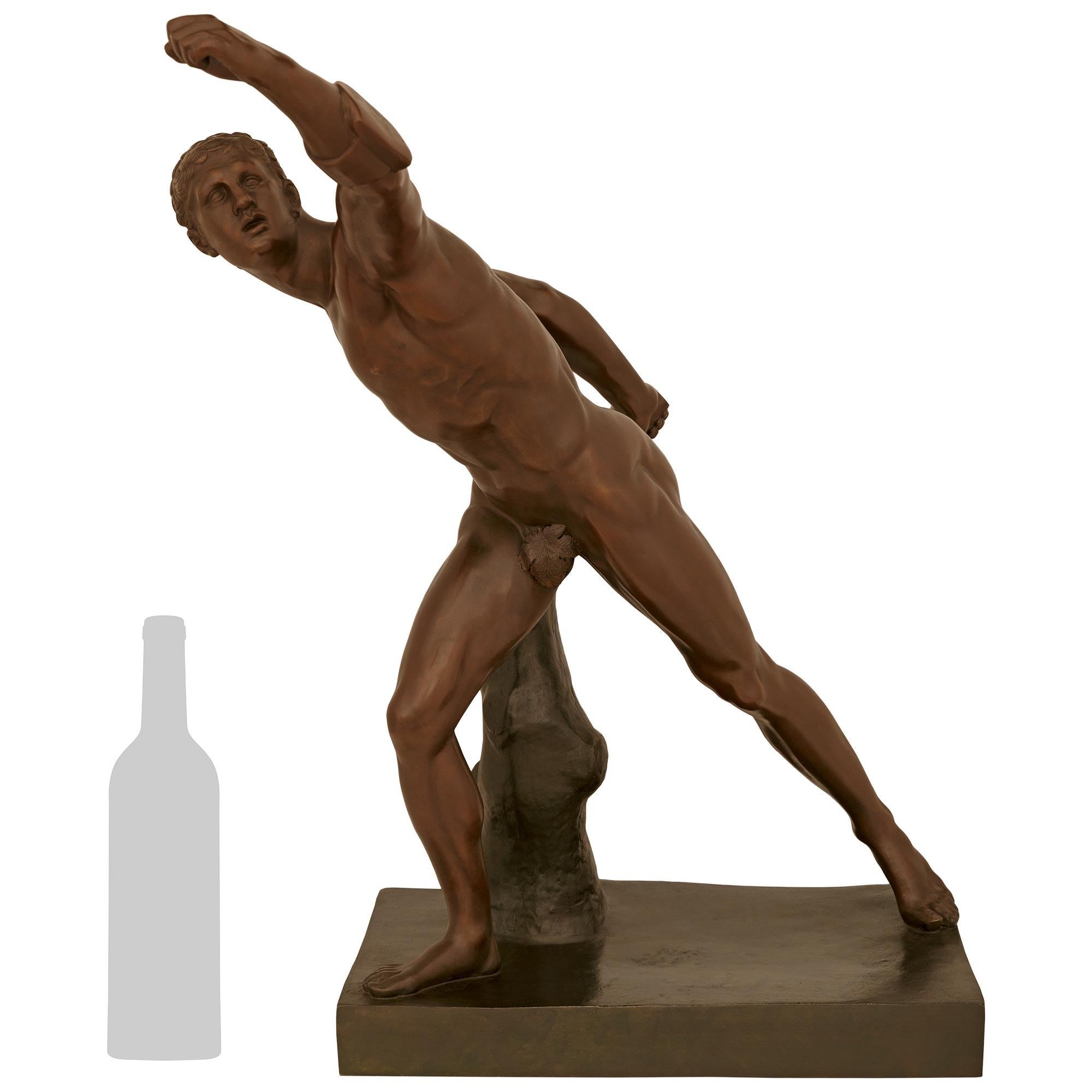 Une impressionnante statue en bronze patiné du Grand Tour du XIXe siècle représentant le gladiateur de Borghese. Le beau Gladiateur est posé sur une base en bronze patiné vert-de-gris avec un motif de terre et une souche d'arbre. Ci-dessus, le
