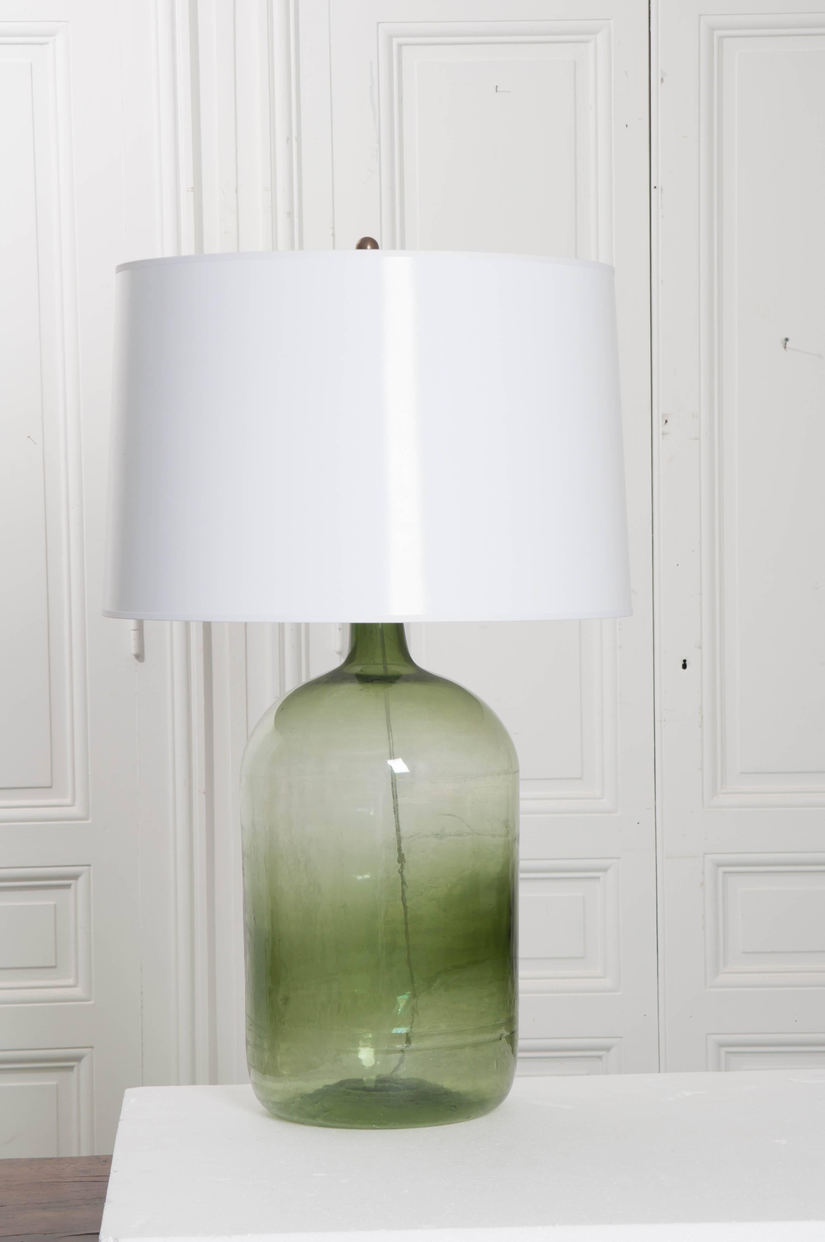 A wonderful antique green-glass wine keg, or “demijohn”, that has recently been made into a fantastic table lamp. Once used to store and transport wine, today this large green bottle provides the base for a most attractive light fixture. The blown
