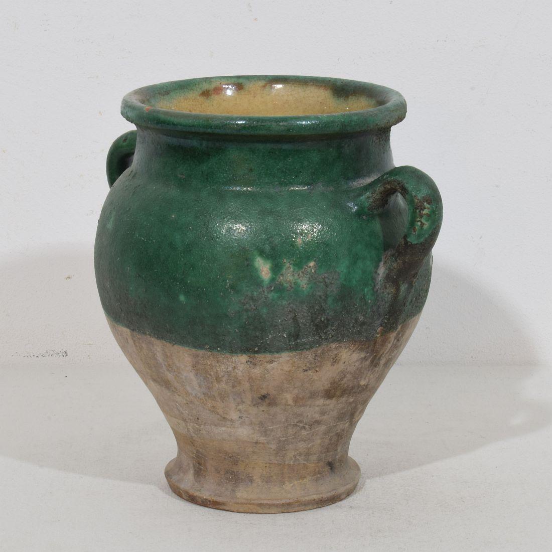 Beautiful weathered confit jar with a gorgeous green glaze. With green glaze they are extremely rare. Confit jars were used primarily in the South of France for the preservation of meats such as duck or goose for dishes such as cassoulet or foie