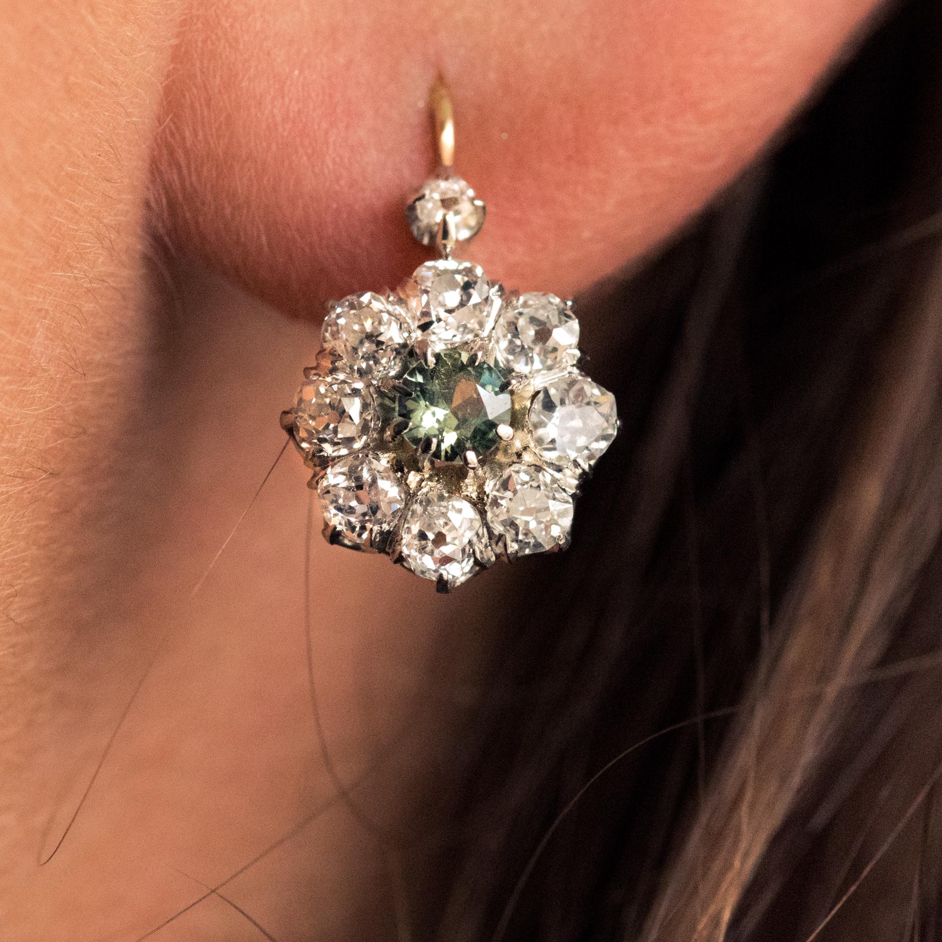 Earring in 18 karat rose gold, eagle's head hallmark.
Antique lever- back earrings, each set in the center with a round green sapphire, surrounded by antique brilliant-cut diamonds. The hanging system is forward.
Total weight of the sapphires :