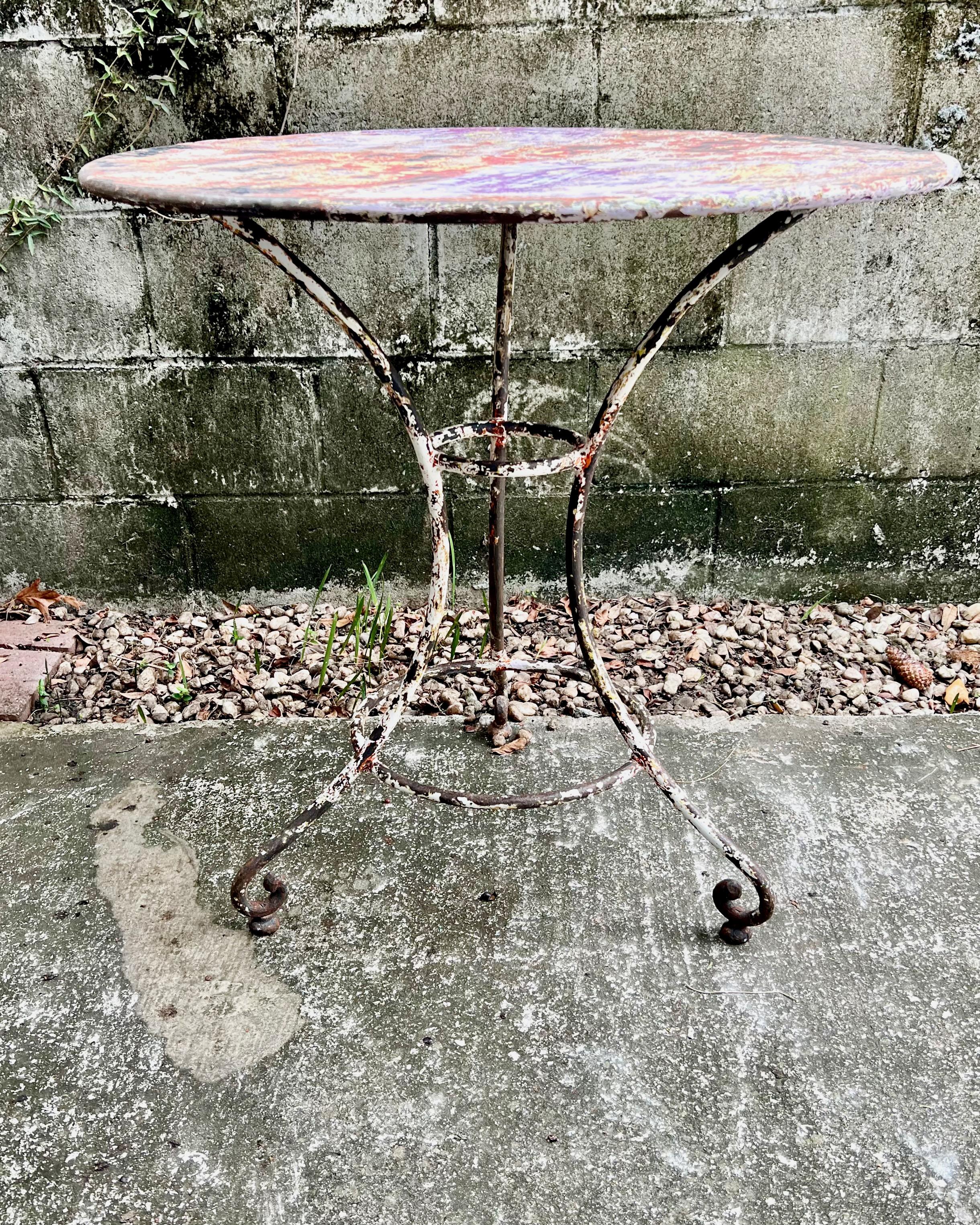 Tavolo da bistrot francese del XIX secolo con piano rotondo su base guéridon di gambe arcuate ad albero che terminano con piedi a voluta e sono unite da una barella centrale - il tutto in patina antica molto interessante.

