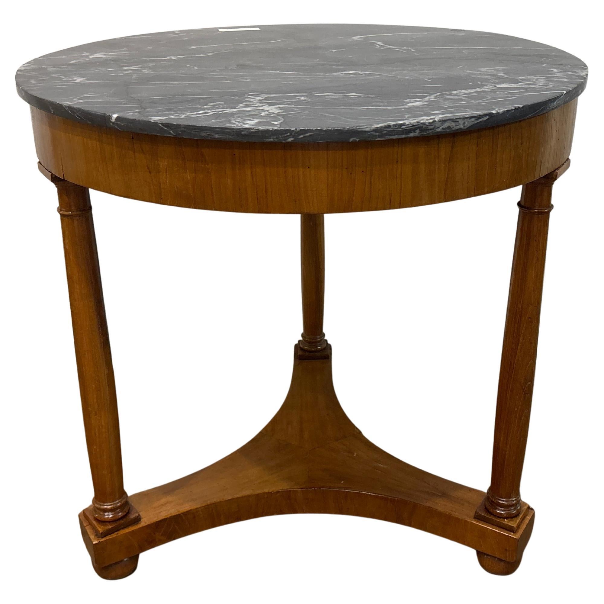 Questo treppiedi Charming Gueridon è realizzato in legno di frutta con un piano in marmo grigio venato.