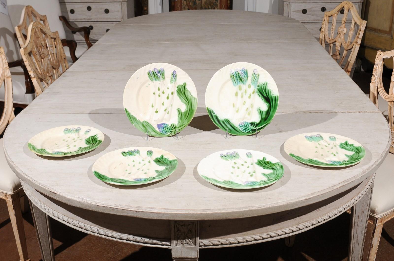 A set of French hand painted Majolica asparagus dinner plates from the late 19th century, with curving green leaves, priced and sold individually. Born in France during the later years of the 19th century, each of this set of Majolica asparagus