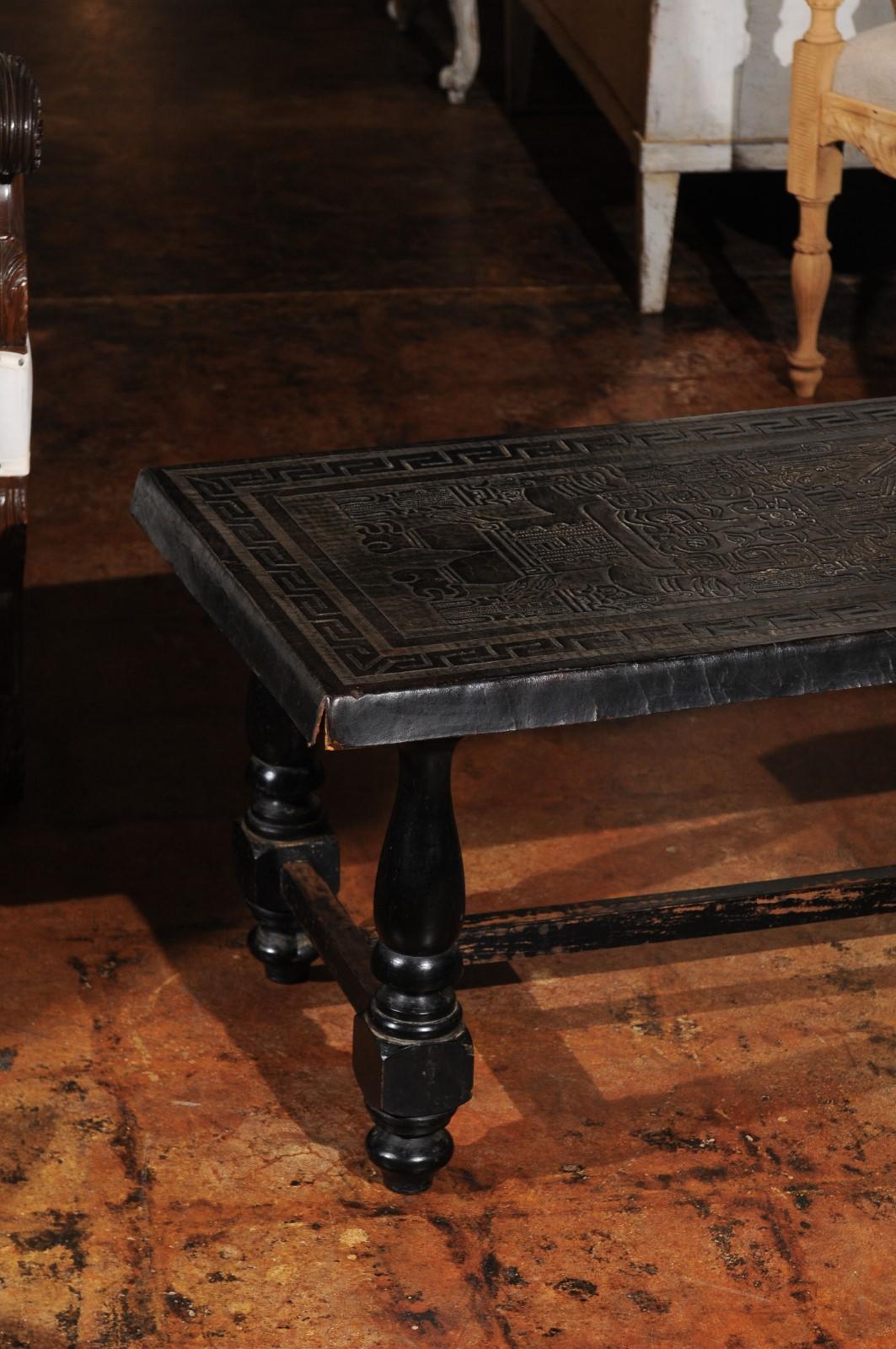 A French turned wood bench from the 19th century, with hand-tooled black leather top and cross stretcher. Born in France during the 19th century, this stylish bench features an exquisite black leather top, adorned with hand-tooled Mesoamerican style