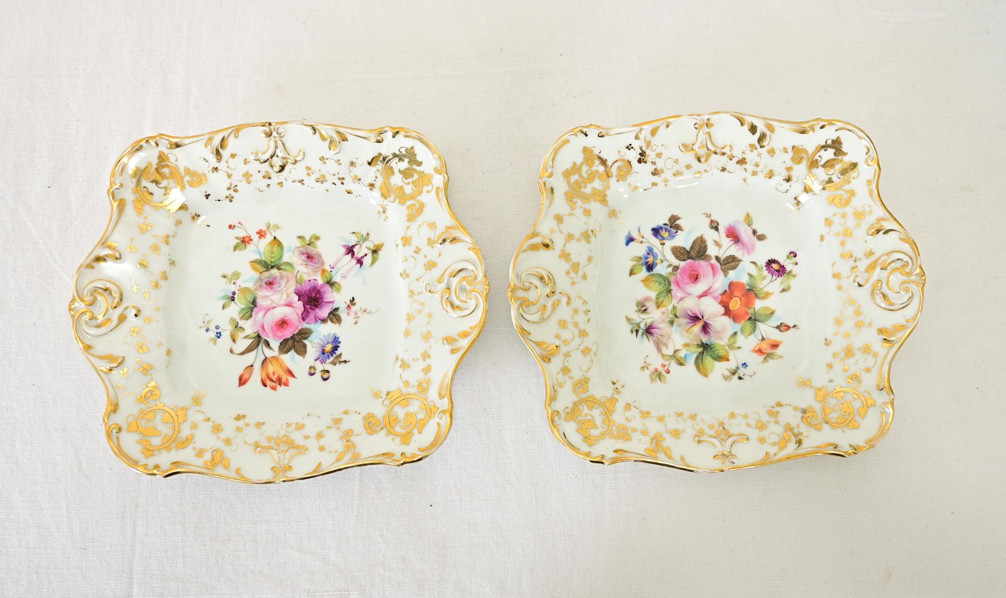 A beautiful pair of French 19th century Bavarian-style handpainted porcelain dishes to add a touch of spring to the table. Each square plate has wonderful rococo scalloping details on the rim, outlined in gold, that spreads toward the center as