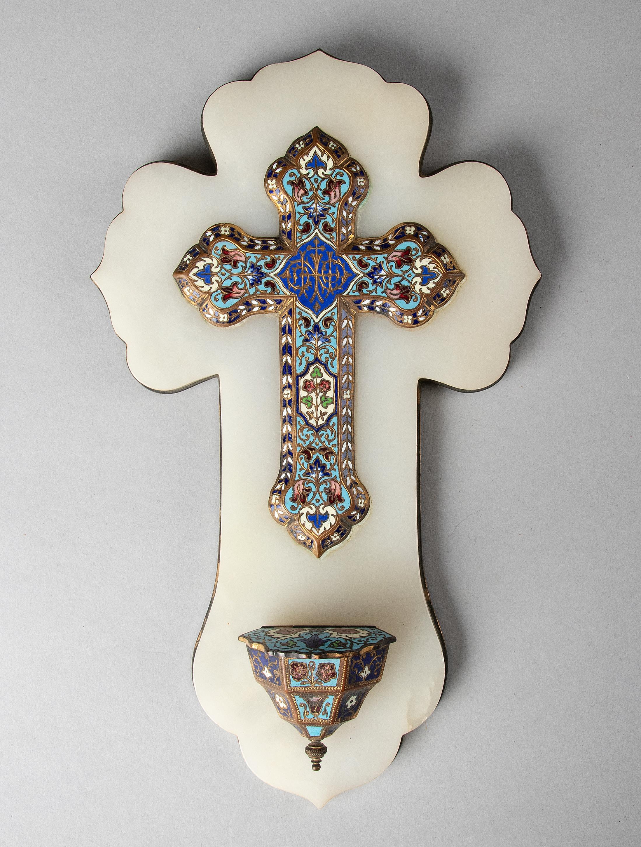 Beautiful antique holy water font in the shape of a cross. The holy water font is made of bronze, inlaid with enamel, a technique also known as cloisonné. The white background is onyx. The holy water font has a copper plate on the back. The water
