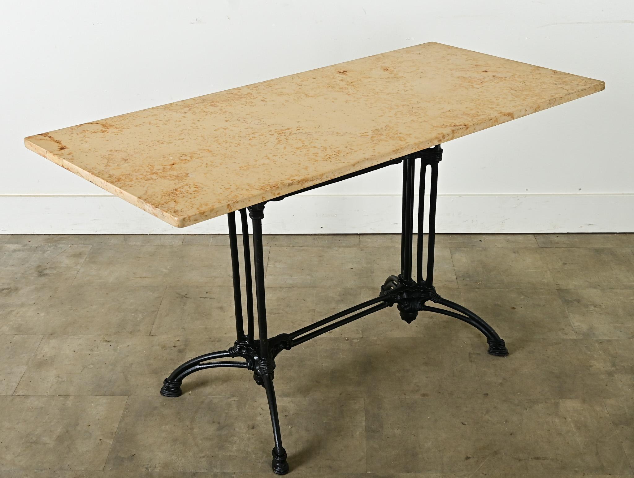 Una encantadora mesa bistro francesa del siglo XIX, perfecta para el entretenimiento o el uso diario, ¡tanto en interiores como en exteriores! El mármol original muestra vetas moteadas en la piedra beige. Los arañazos y manchas del material son
