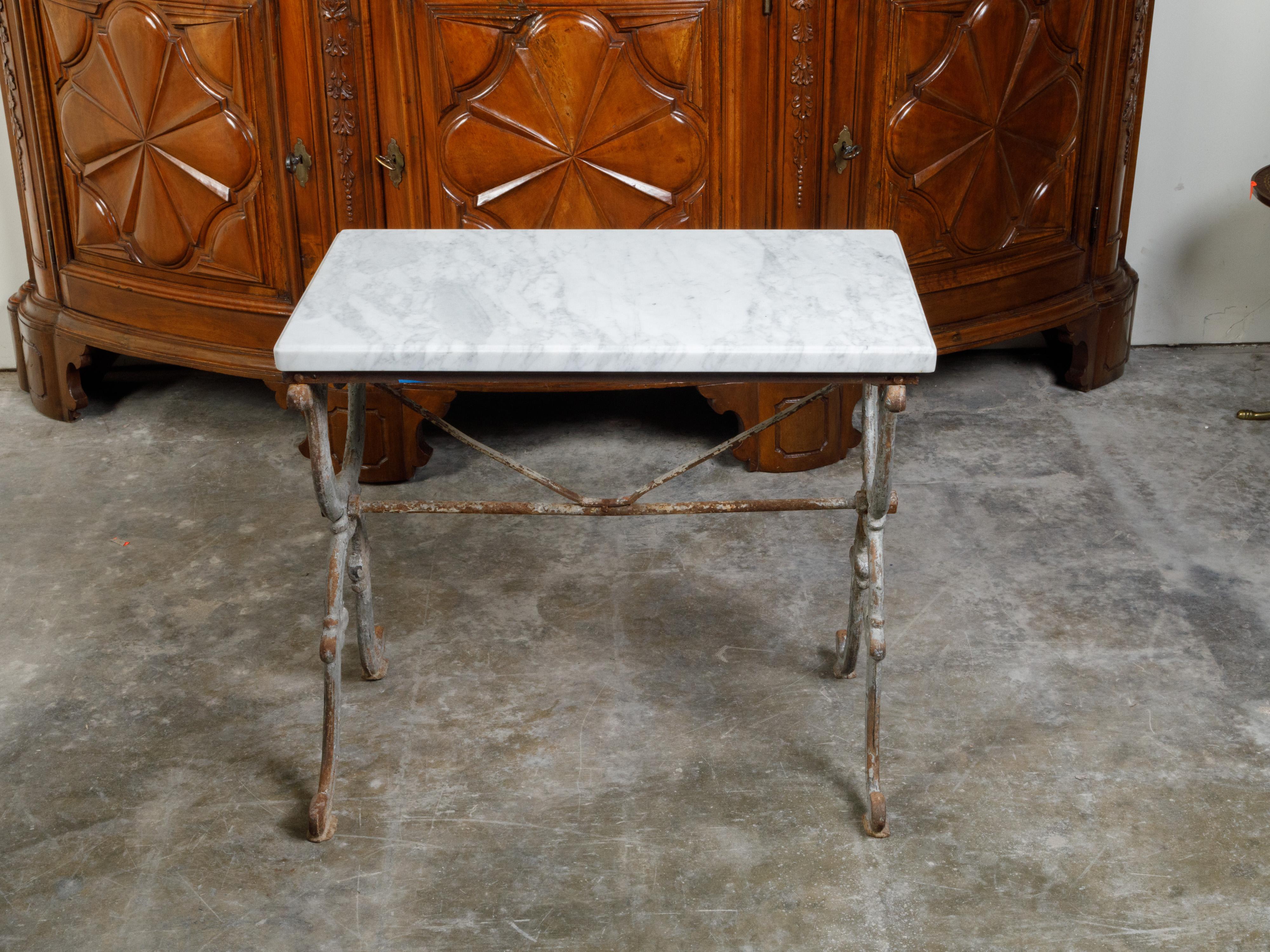 A French iron console table from the 19th century, with white marble top and X-Form base. Created in France during the 19th century, this console table features a rectangular white marble top sitting above an elegant double X-Form base with cross