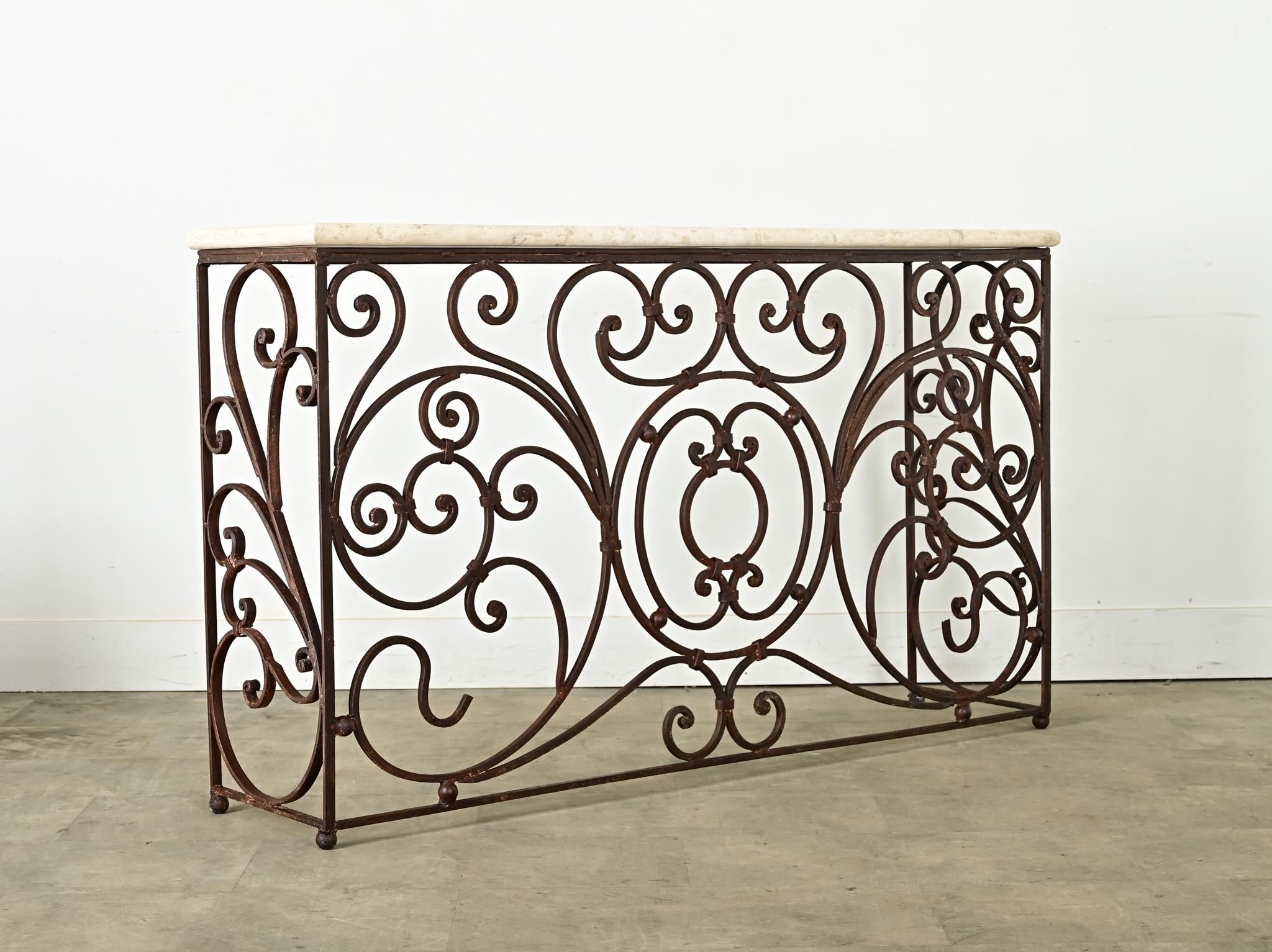 This baroque style 19th French console has a patinated finish over elegant wrought iron scroll work from its previous life as balcony railing. The architectural fragment was repurposed by receiving a (neutral) beige marble top, a feature that will