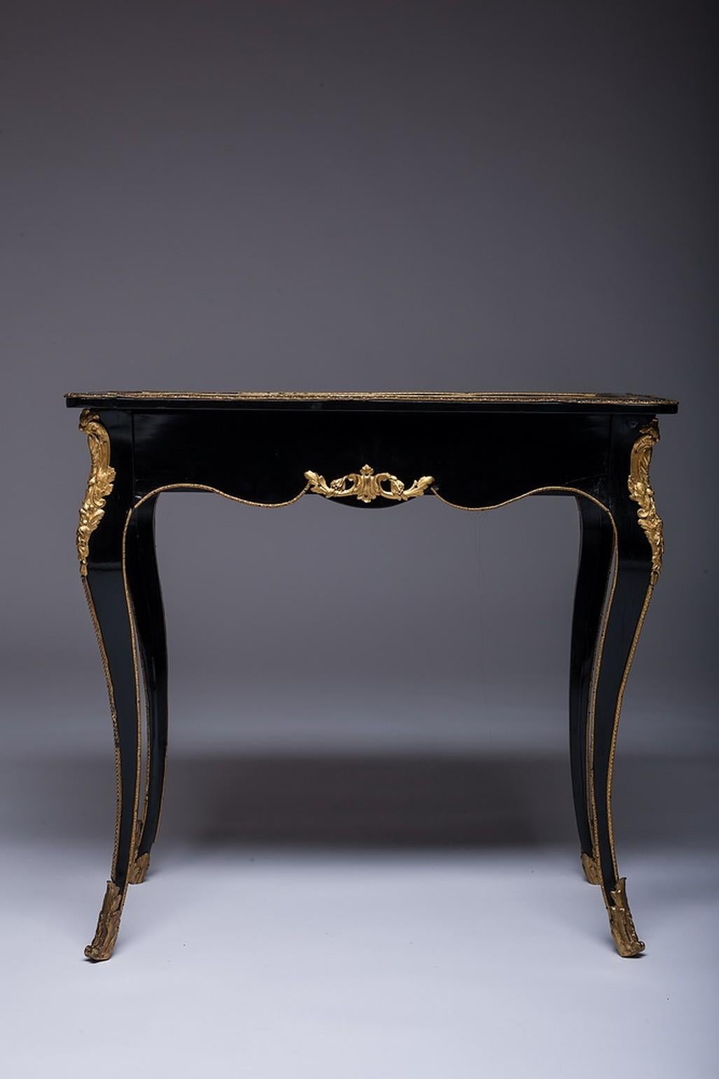 Very rare 19th century French desk in ebony with bronze. French Napoleon III bureau plat - desk. It is ebonized with lacquered wood, with bronze mounts. The top is inset with black Japanese lacquer. The Bureau plat cabriole legs is garnish with gilt