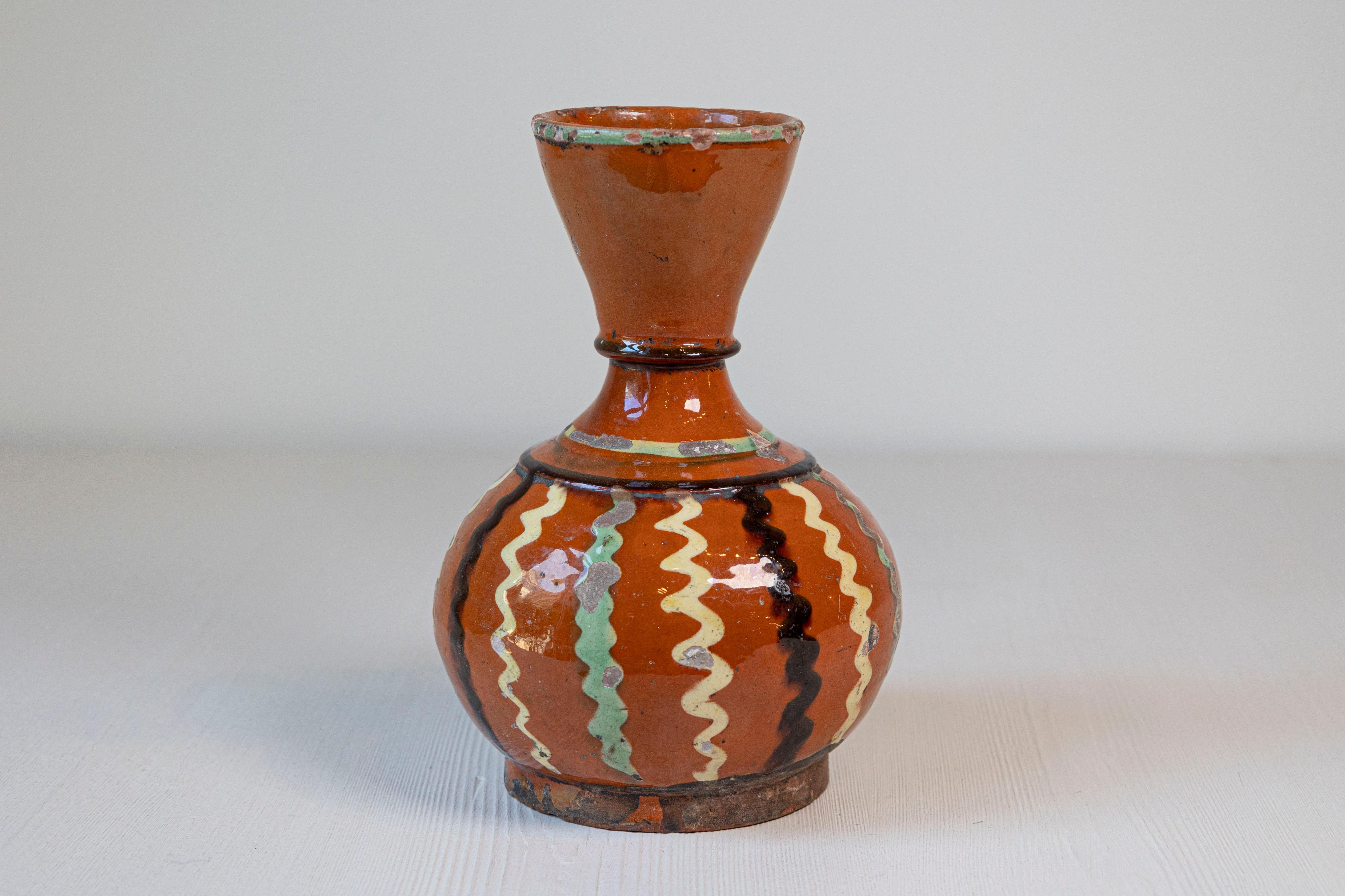 Verseuse à vin en poterie jaspe française du XIXe siècle, à glaçure rouille et décor ondulé noir, crème et vert tendre. Créée en France au XIXe siècle, cette cruche à vin présente un fond de couleur rouille parfaitement accentué par des lignes