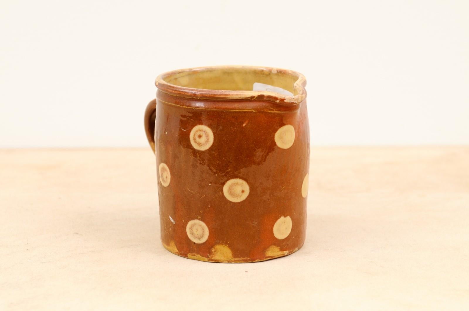 A French jaspé ware pottery pitcher from the 19th century, with brown glaze and cream polka dots. Created in France during the 19th century, this French jaspé pitcher attracts our attention with its brown glaze, simply adorned with cream polka dots.