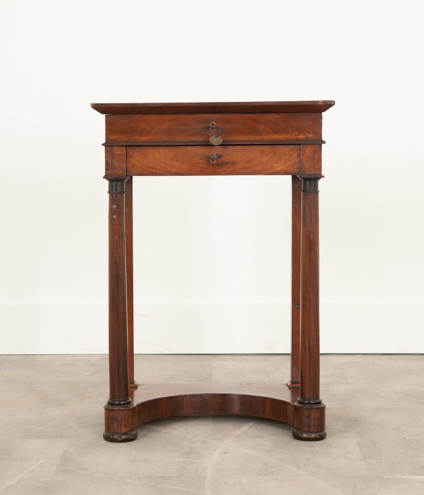 This petite work table from 19th century France is full of charming elements within a compact design. Details allude to this piece serving as a correspondence and sewing table. Unlocking what seems to be a drawer actually allows the top to hinge