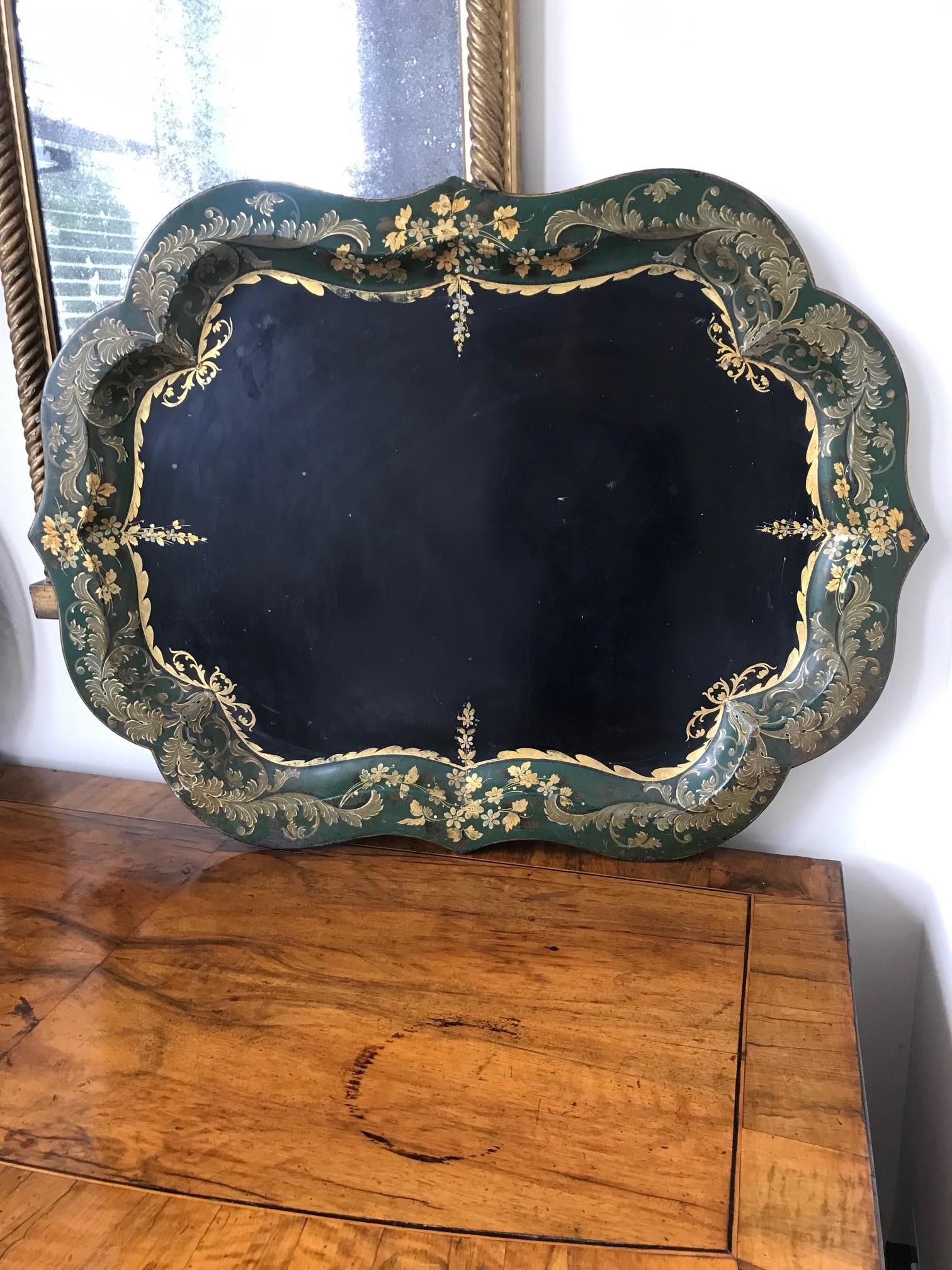 A French 19th century large tole tray of elegant form with distinctive black color and hand painted gold leaf foliage detail, on green colored border.