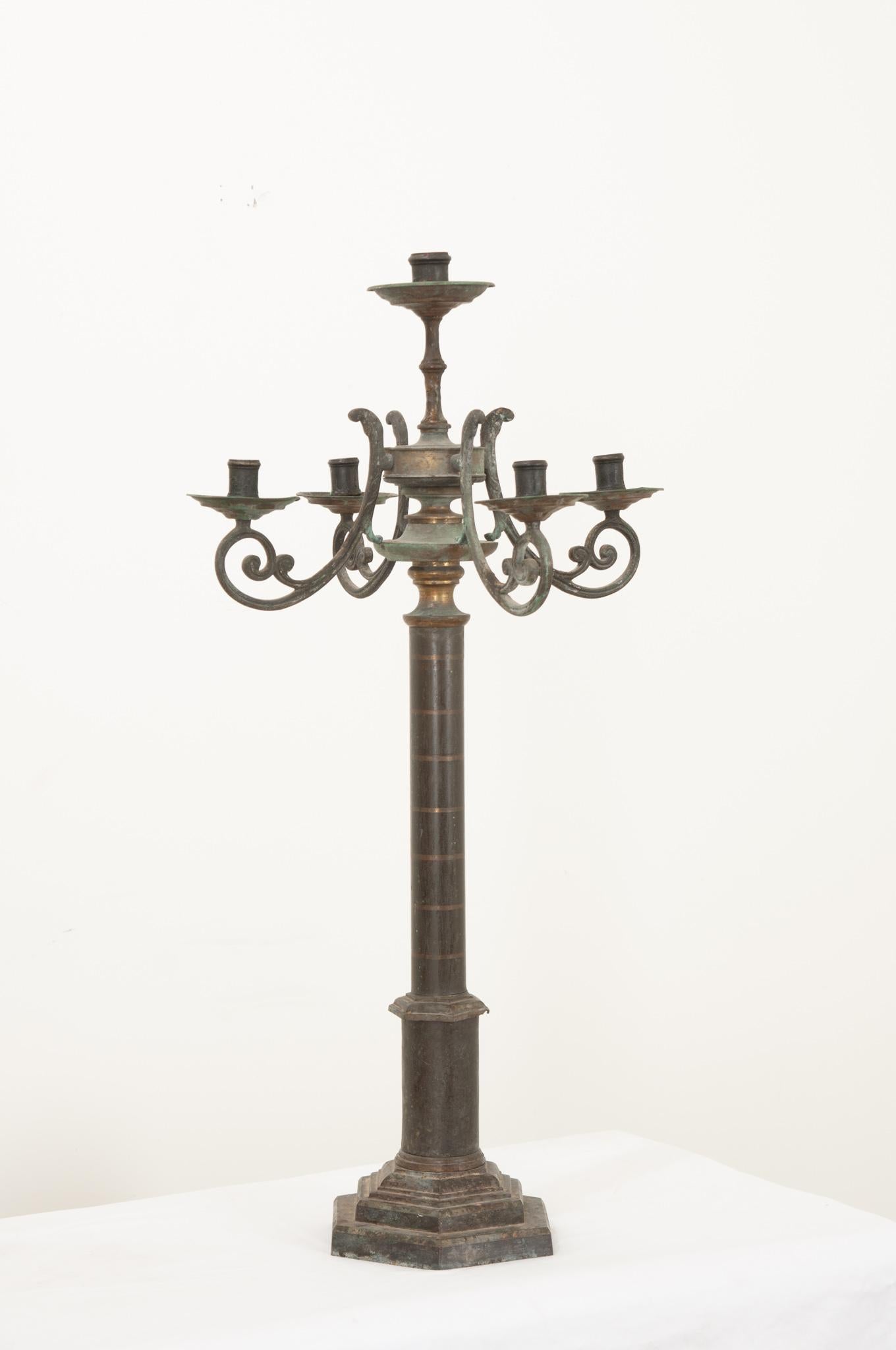 This generously sized five-arm candelabra has gained a wonderful patina since its creation during the 1890’s in France. A single arm is raised above the rest while four scrolling arms support the raiminging bobeches. The center stem subtly displays