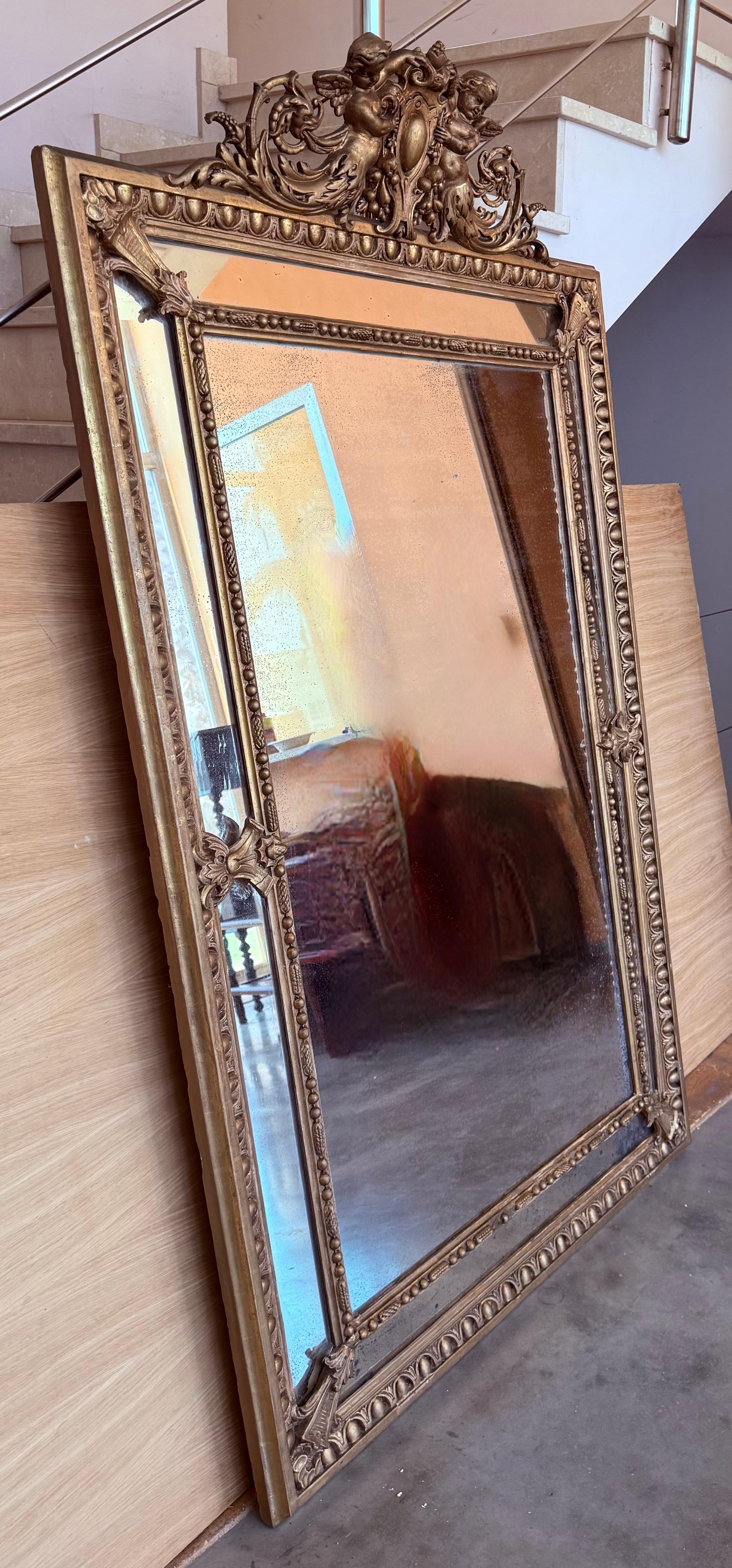 French Provincial French 19th Century Large Vertical Gold Gilt Mirror with Cherub crest For Sale