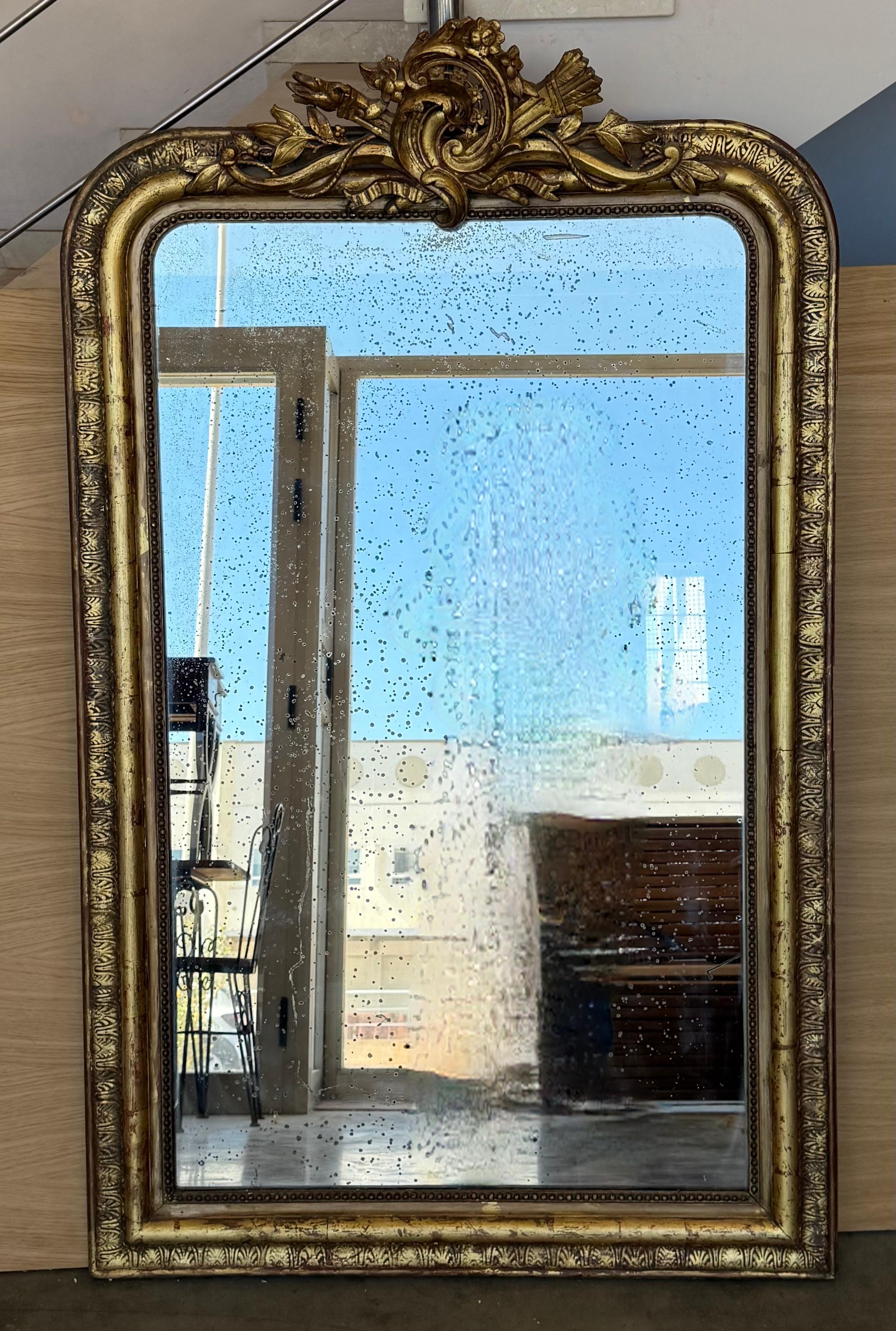 An exceptional large scale mirror hand-crafted in France, this piece is vertical symmetrical and the original mirror plate sparkles with diamond dust.. This mirror is beautiful and features an exquisitely carved repeating Neoclassical design around