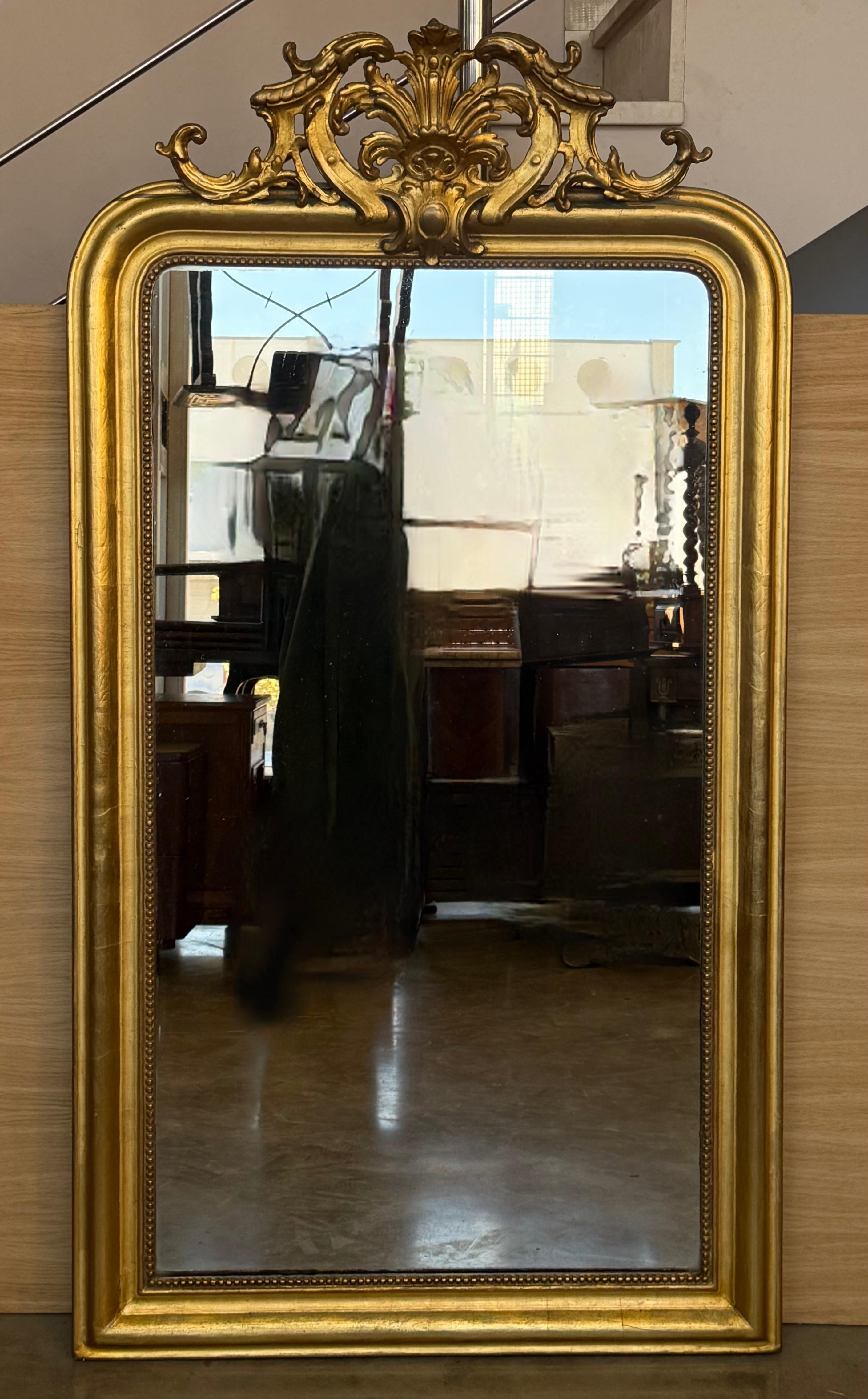 Ce miroir exceptionnel de grande taille, fabriqué à la main en France, présente une symétrie verticale et la plaque de miroir d'origine scintille de poussière de diamant... Ce miroir est magnifique et présente un motif néoclassique répétitif