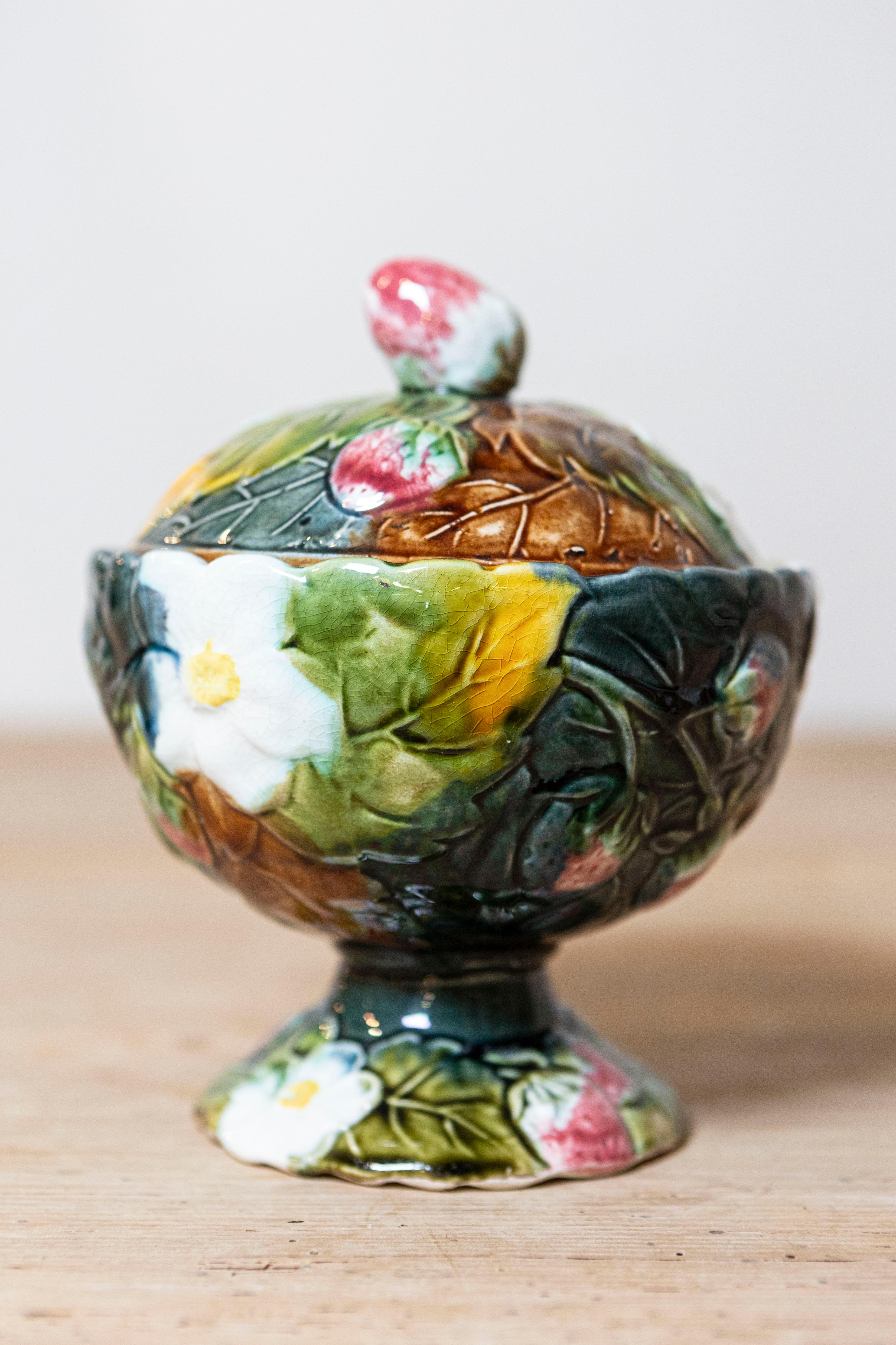 A French majolica lidded bowl from the 19th century, with strawberry motif, white flowers and foliage. Created in France during the 19th century, this bowl features a circular lid accented with a strawberry-themed handle and adorned with delicate