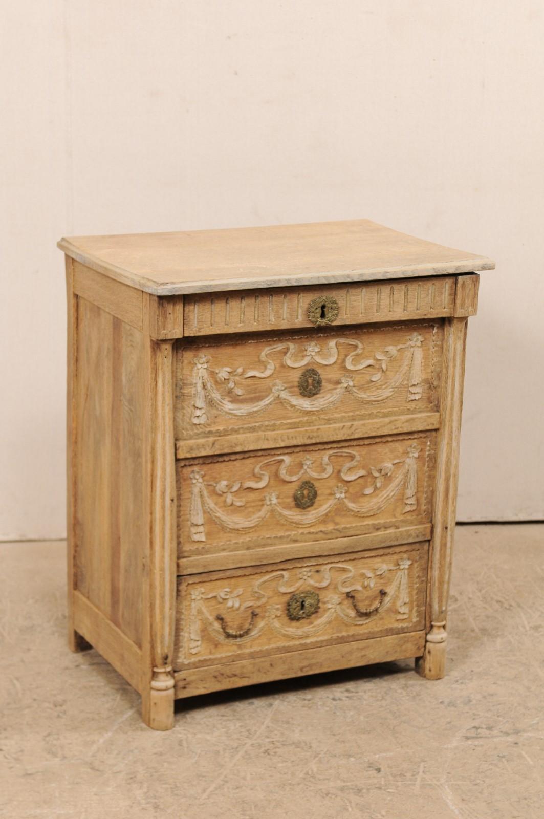 A French carved wood cabinet with lift-top and single drawer from the 19th century. This antique commode from France features a rectangular-shaped top which rests upon a case with two faux carved drawers and one functional bottom drawer, all nicely