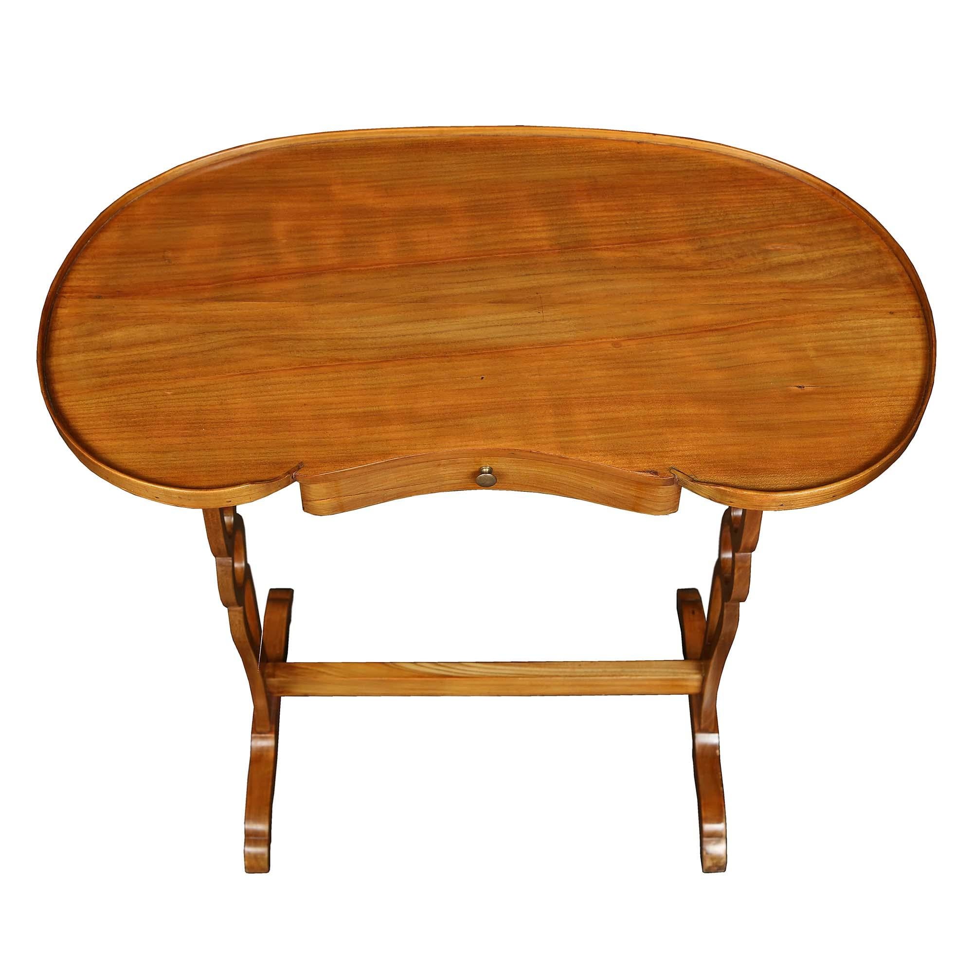 A charming French 19th century light cherry, kidney shaped table. The table is raised by two pierced trestle supports joined by a straight stretcher. The top has a kidney shaped border above one drawer with a brass knob.