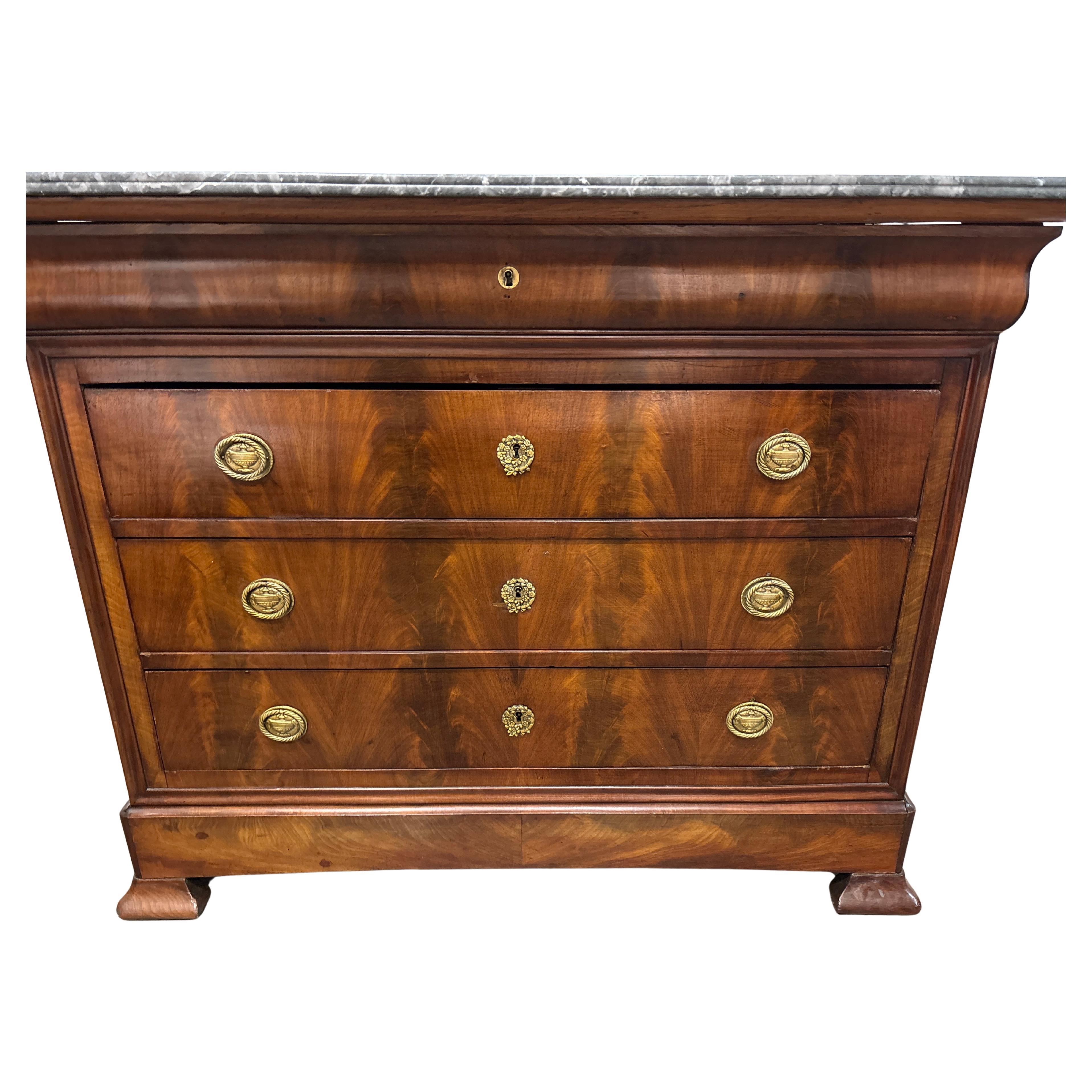 This Commode is made of a beautiful flamed mahogany with a Saint-Anne marble top. It has 4 drawers.